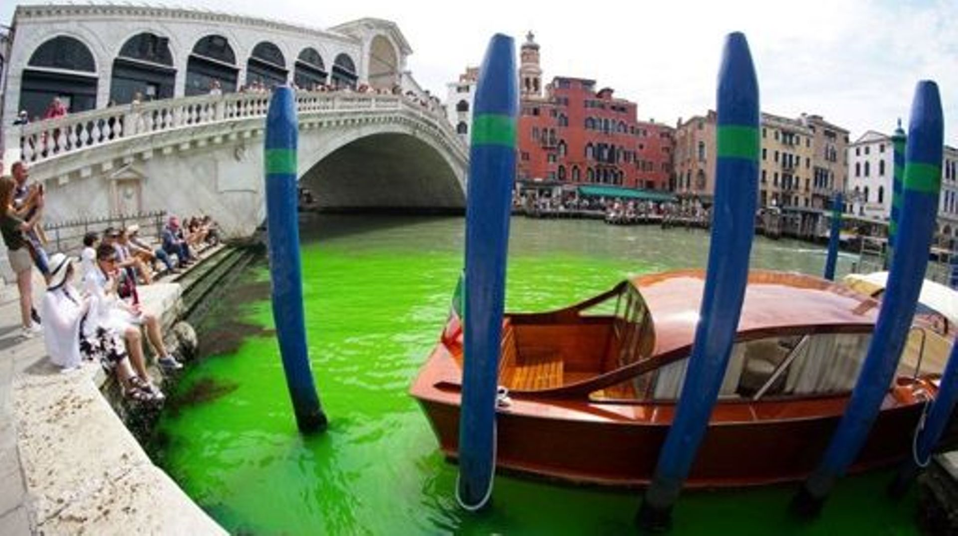 A photo taken and made available on May 28, 2023 by Italian news agency Ansa, shows fluorescent green waters below the Rialto Bridge in Venice's Grand Canal. The prefect called an urgent meeting on May 28 with the police to investigate the origin of the l