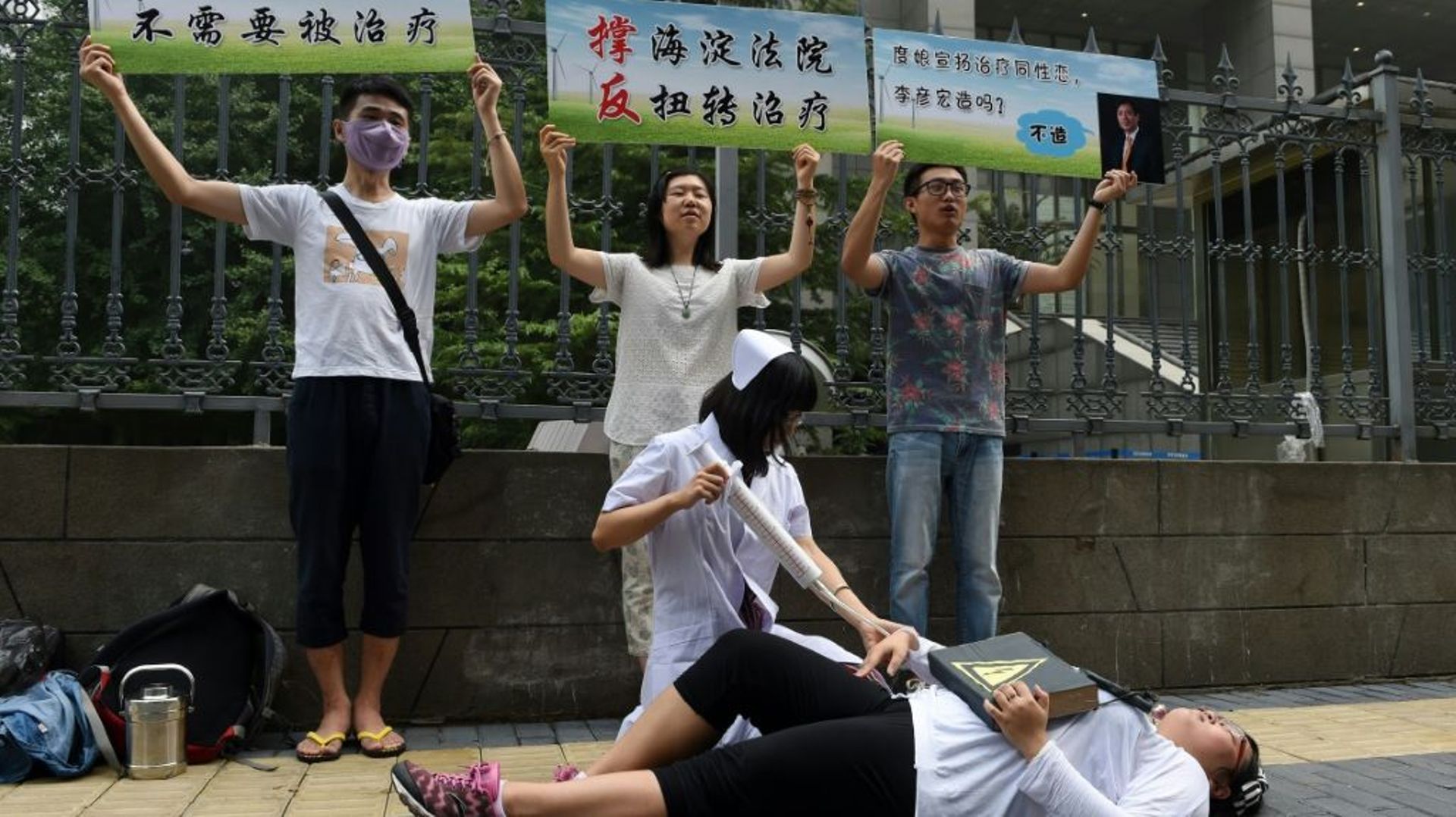 Des militants du centre LGBT de Pékin miment l'injection d'un patient à l'aide d'une seringue géante pour dénoncer les "cures" contre l'homosexualité pratiquées en Chine, le 31 juillet 2014 à Pékin