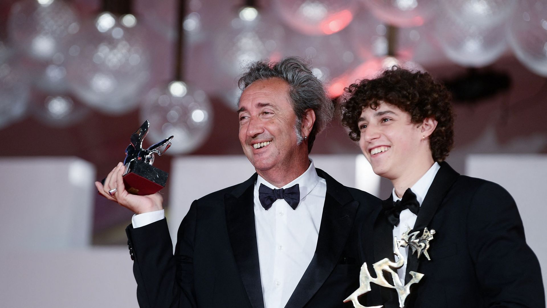 Le réalisateur italien Paolo Sorrentino pose avec le Lion d’argent – Grand prix du jury qu’il a reçu pour "E stato la mano di Dio" (La main de Dieu), ainsi que l’acteur italien Filippo Scotti tenant le prix "Marcello Mastroianni" lors de la cérémonie du 7