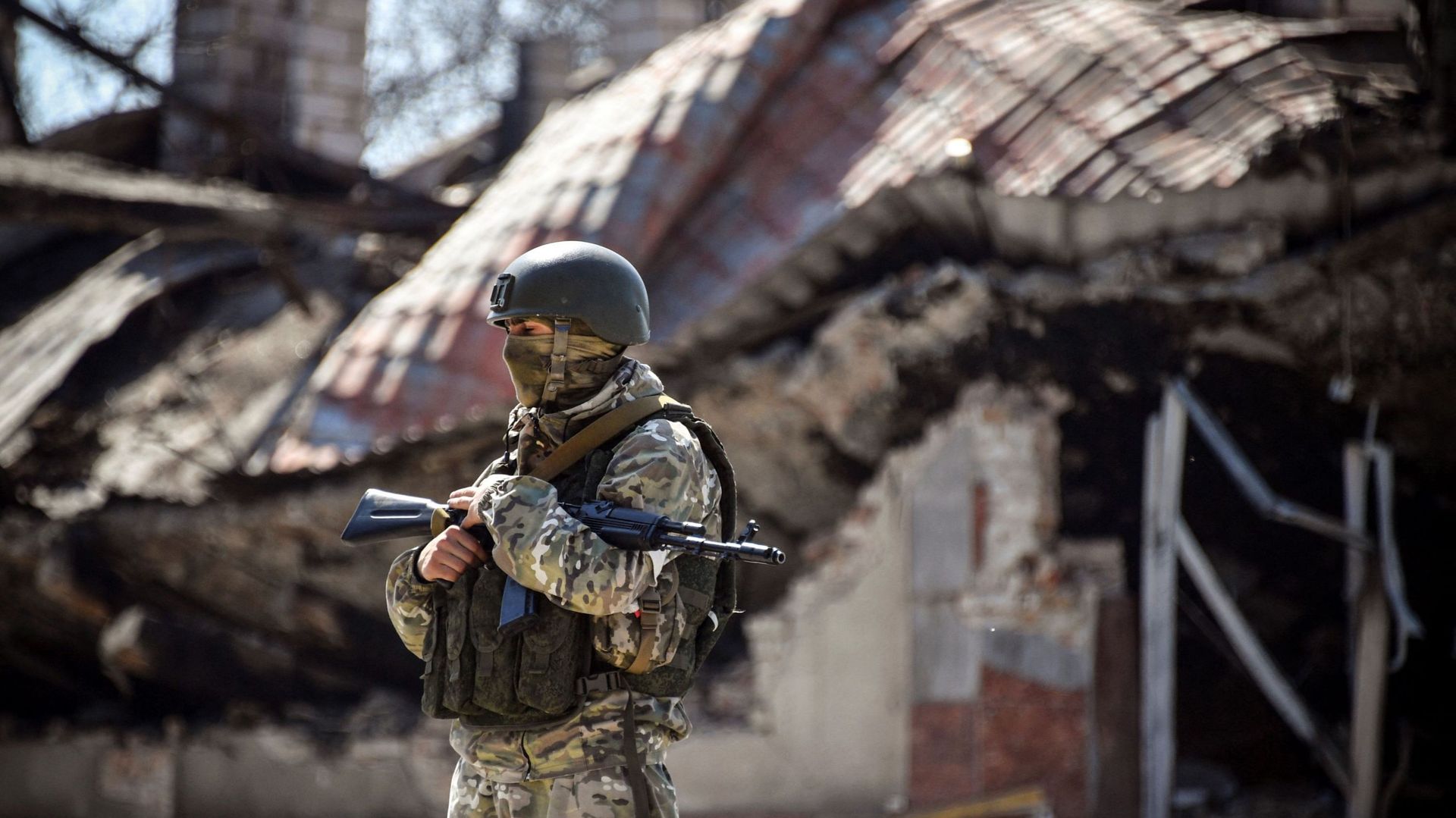 Un soldat russe se tient devant un immeuble d’appartements, le 11 avril 2022, à Volnovakha dans la région de Donetsk.
