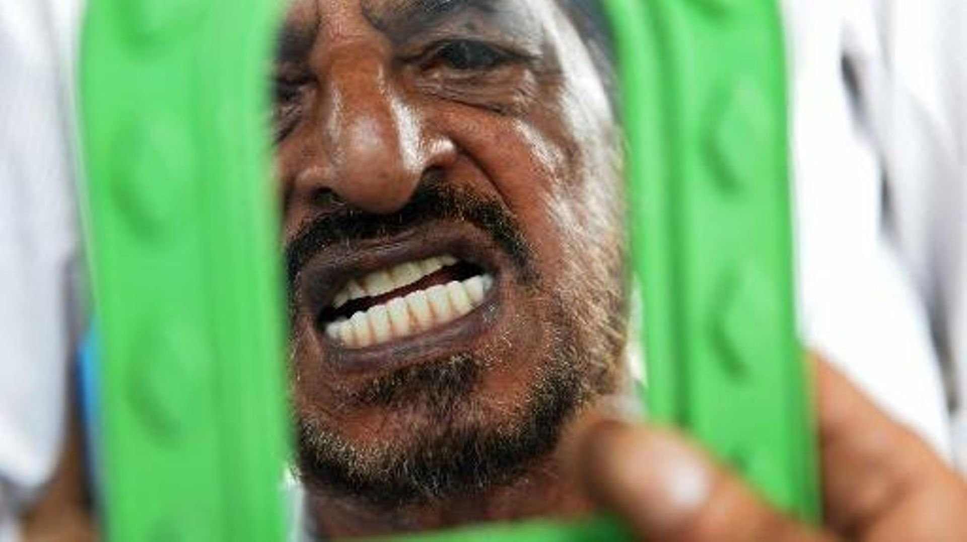 Un homme soigné par Allah Baksh, dentiste de rue,  le 5 mai 2015 à Bangalore 