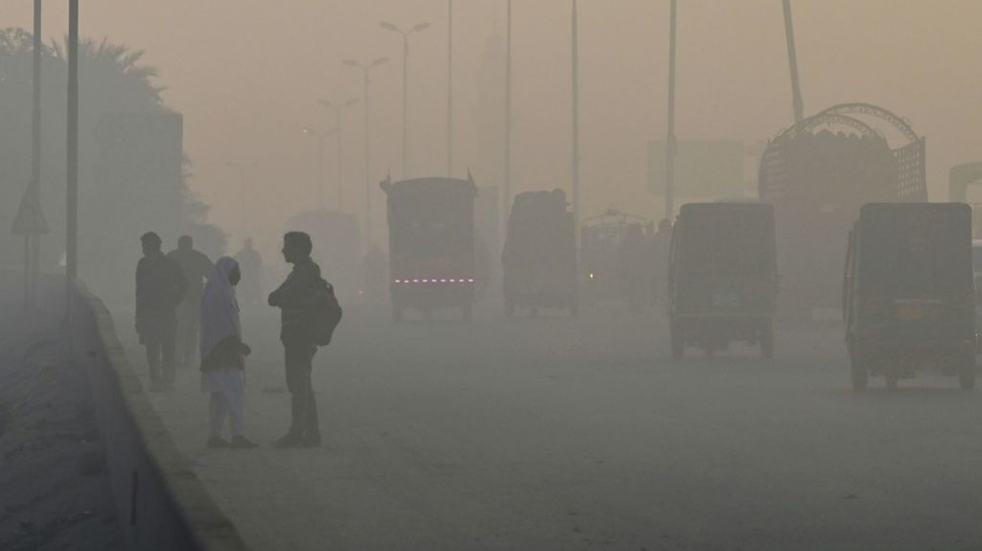 Des élèves au bord d’une route en plein smog, à Lahore au Pakistan le 7 décembre 2022