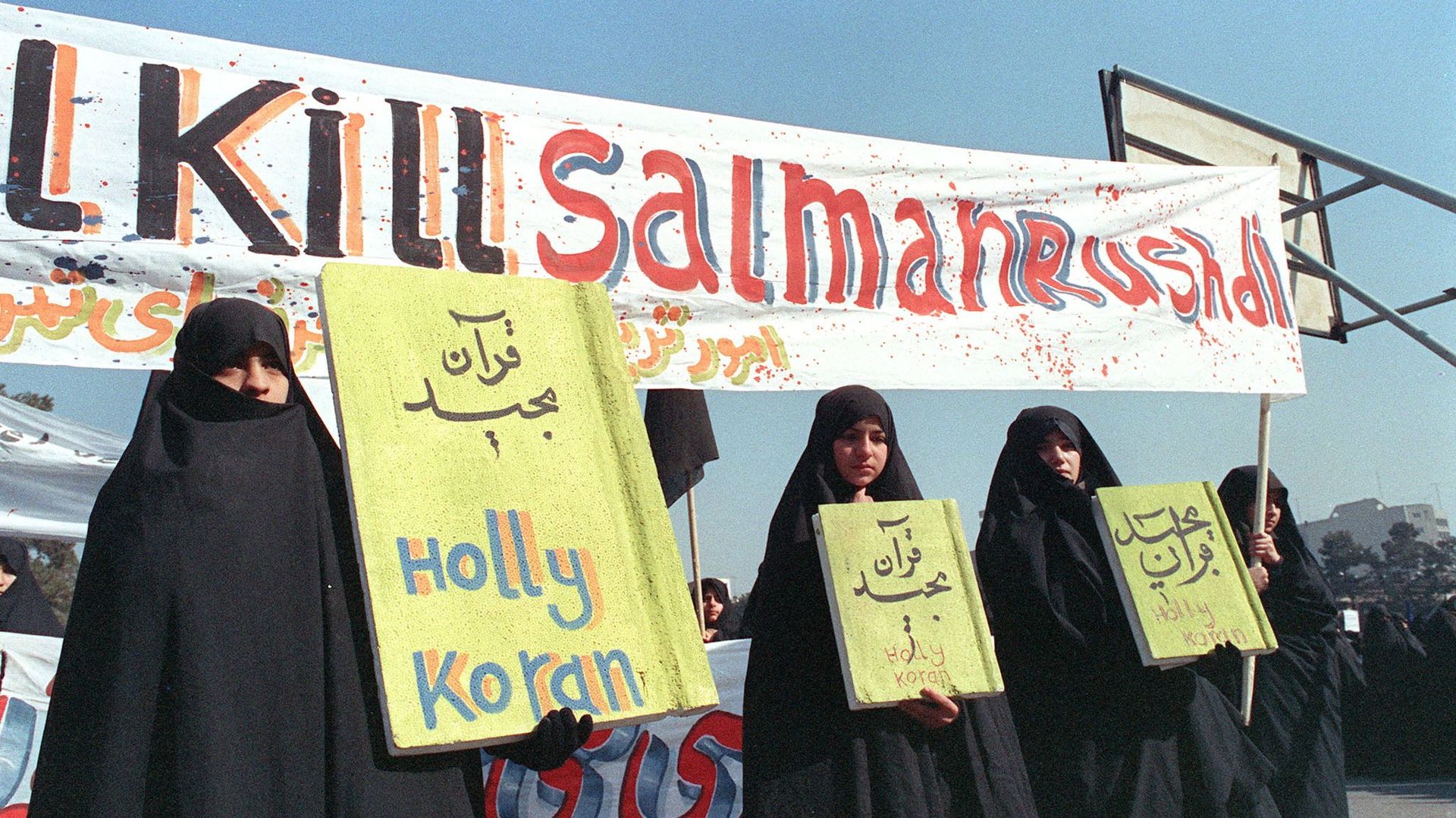 Sur cette photo d’archive prise le 17 février 1989, des Iraniennes tiennent des banderoles sur lesquelles on peut lire "Holly Koran" et "Kill Salman Rushdie" lors d’une manifestation contre l’écrivain britannique Salman Rushdie à Téhéran.
