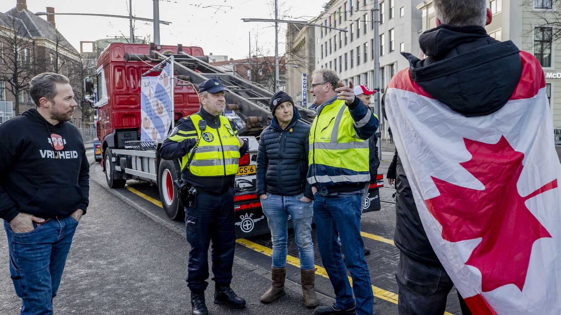 Plus tôt dans la journée, des policiers parlaient à des manifestants portant un drapeau canadien à l’entrée du Binnenhof lors d’une manifestation contre les mesures corona, à La Haye. L’action s’inspire du soi-disant convoi de la liberté au Canada avec le