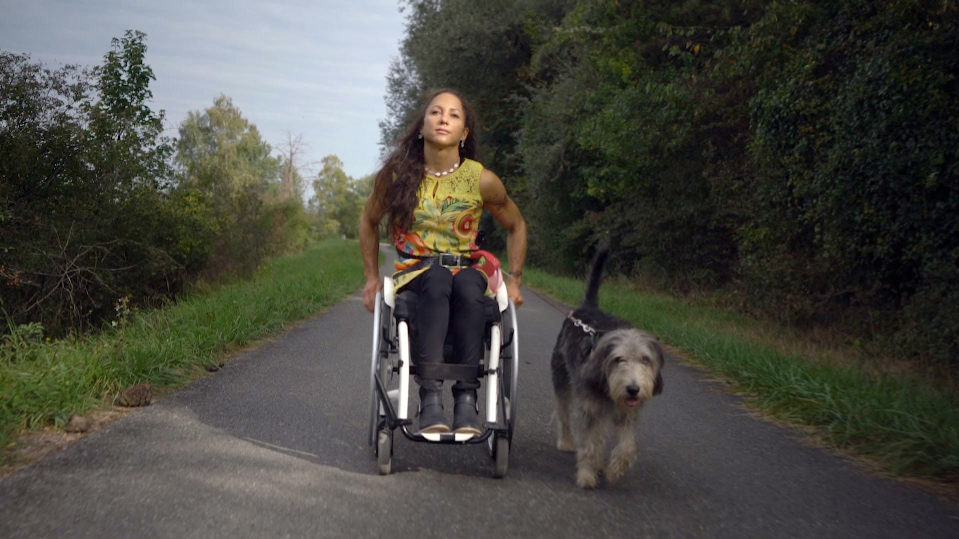 Extrait du documentaire "Jeunes et paraplégiques". Silke pose fièrement en fauteuil roulant avec son chien.