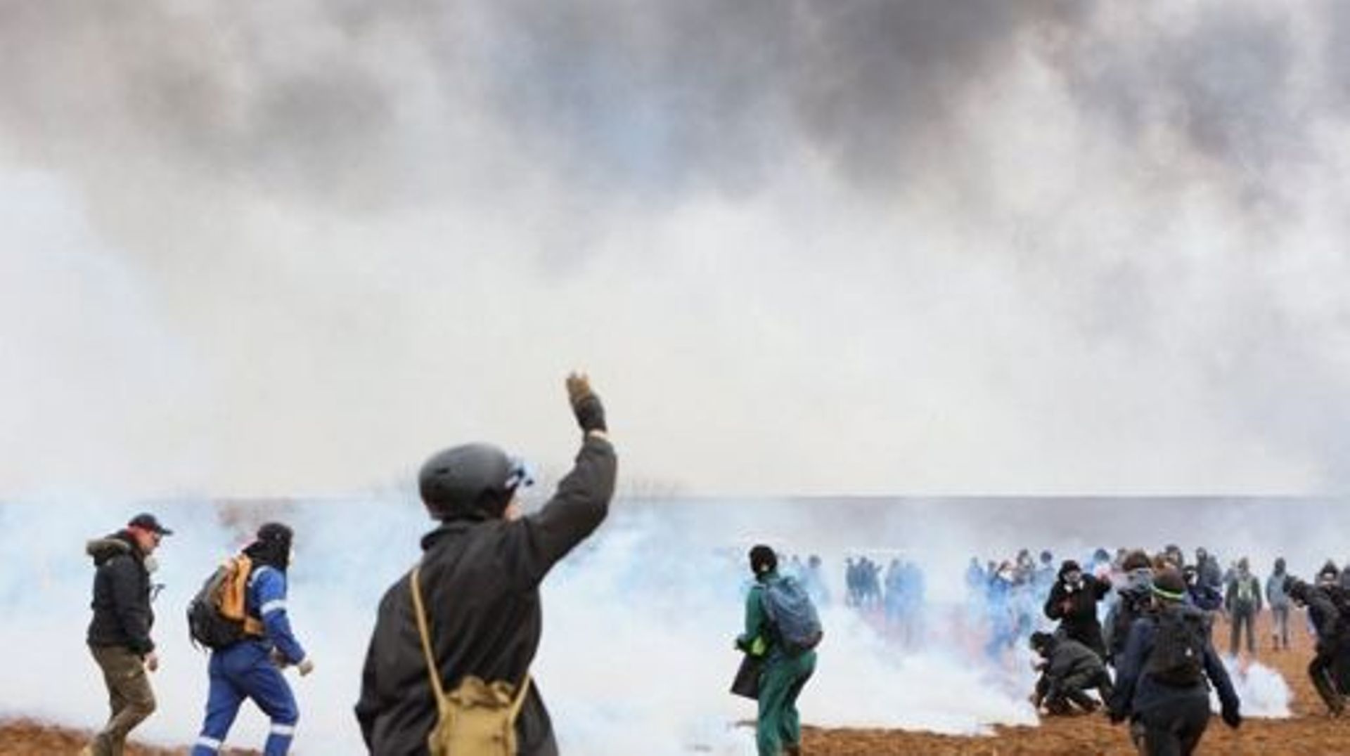 Protesters stand amid tear gas as they clash with riot mobile gendarmes during a demonstration called by the collective "Bassines non merci", the environmental movement "Les Soulevements de la Terre" and the French trade union 'Confederation paysanne' to 