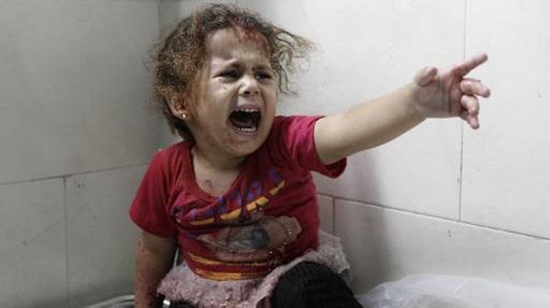 Une petite fille palestinienne hurle à l'hôpital al-Shifa après la destruction de la maison familiale de Gaza le 18 juillet 2014