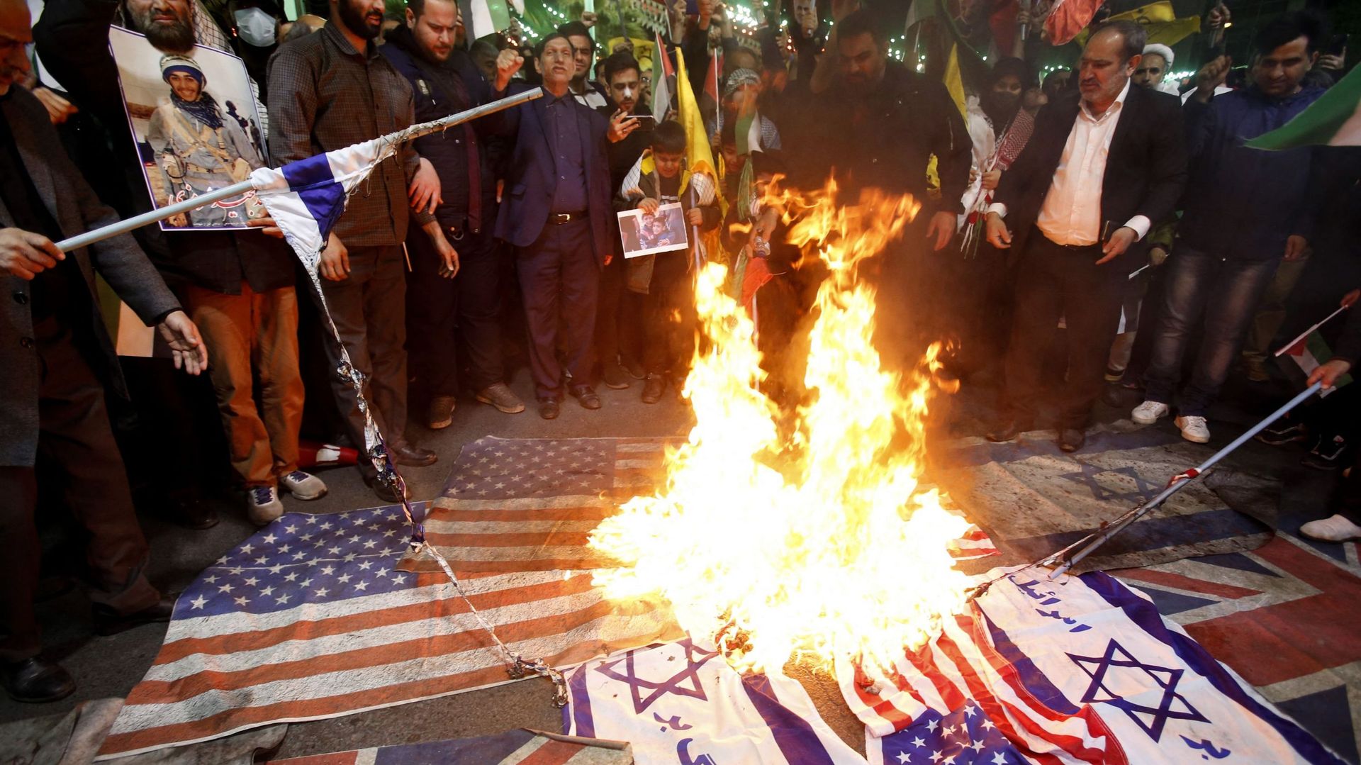 Des Iraniens brûlent des drapeaux israéliens et américains lors d’une manifestation sur la place de la Palestine à Téhéran