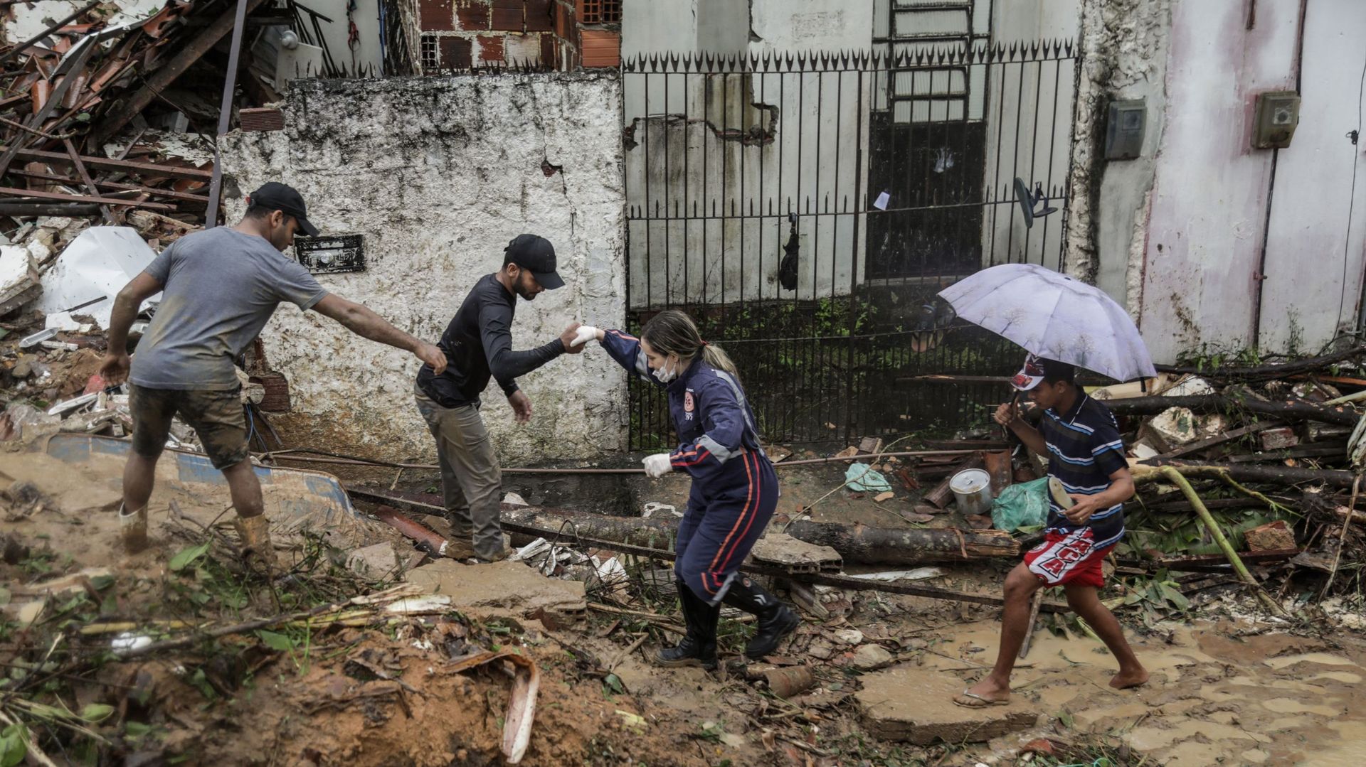 Cette photo distribuée par la mairie de Recife montre des habitants et des secouristes marchant au milieu des débris d'un glissement de terrain qui a détruit plusieurs maisons dans la communauté Jardim Monte Verde, dans le quartier d'Ibura, à Recife, dans