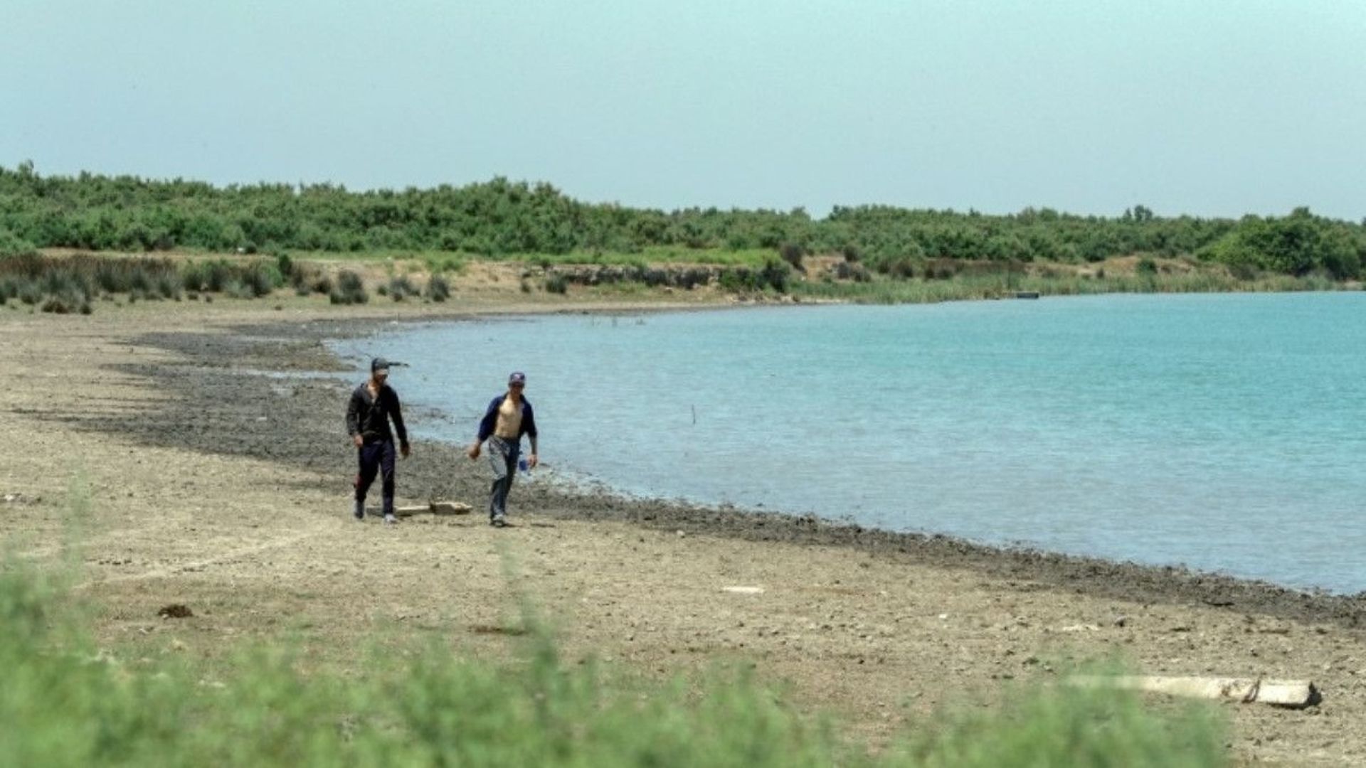 Deux hommes marchent sur la rive du fleuve Koura, le 5 juillet 2020 en Azerbaïdjan.