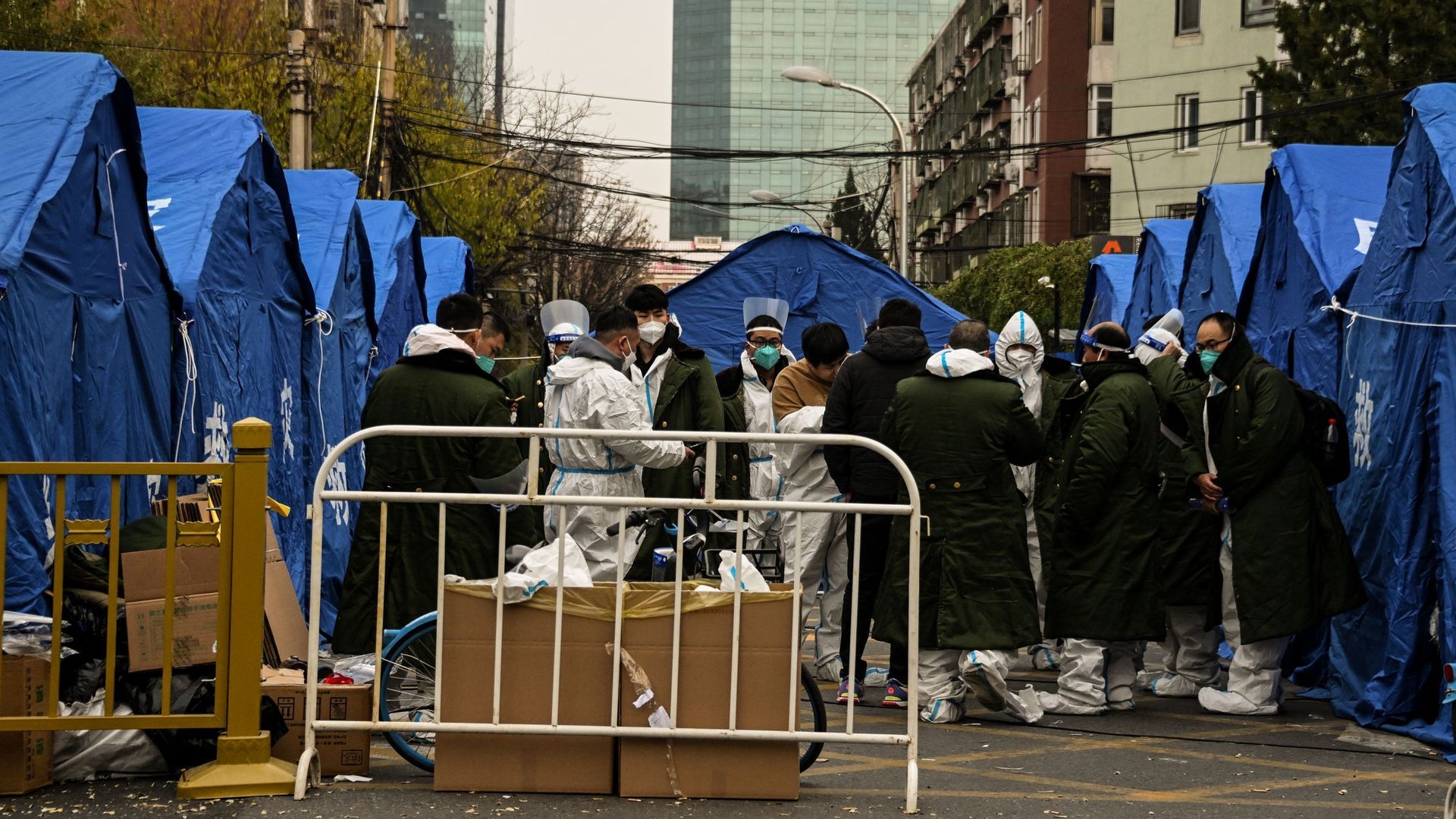 Du personnel de sécurité portant des équipements de protection individuelle près d’une zone résidentielle sous confinement en raison des restrictions liées au Covid-19, à Pékin, le 22 novembre 2022.