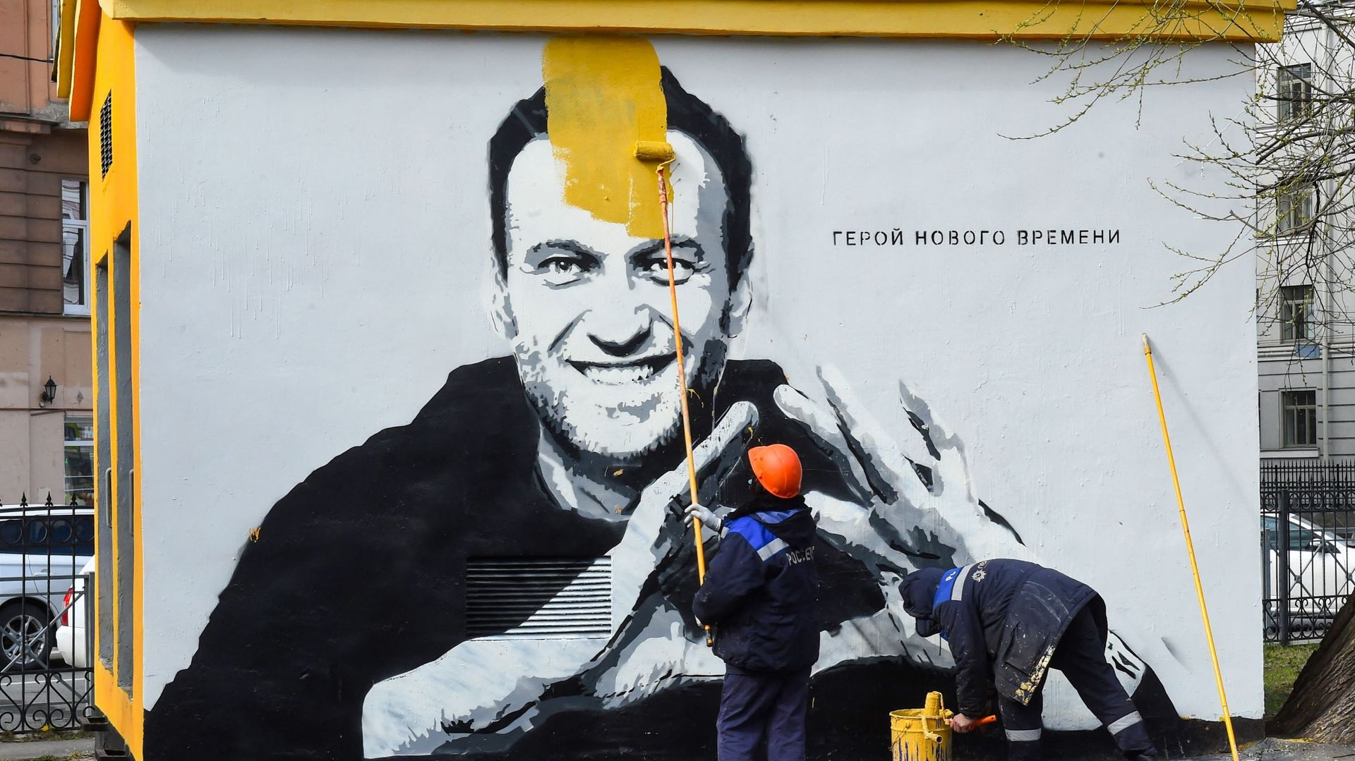 Un ouvrier peint sur un graffiti d'Alexei Navalny, critique du Kremlin emprisonné, à Saint-Pétersbourg, le 28 avril 2021. L'inscription se lit comme suit : "Le héros des temps nouveaux".