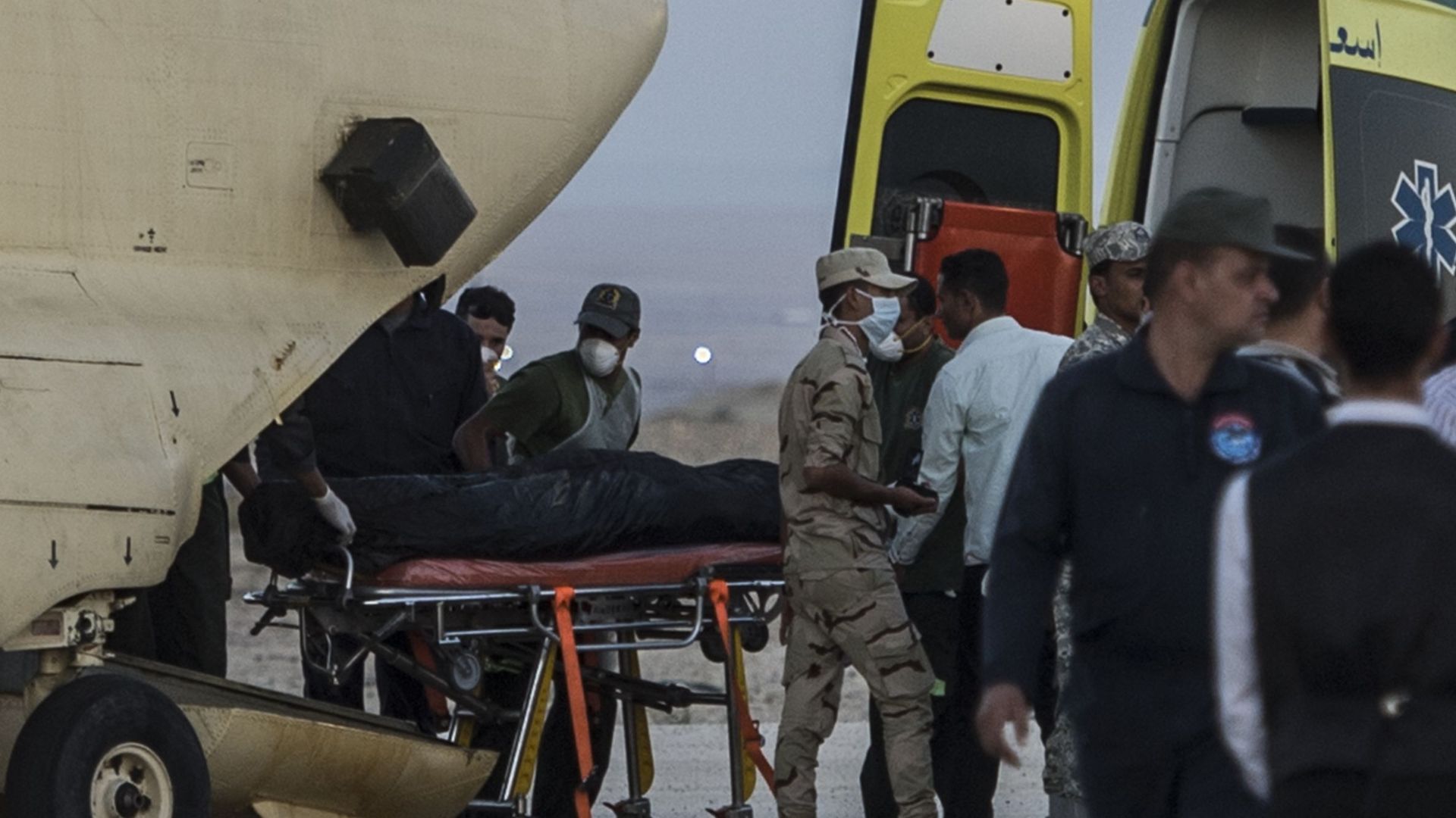 Des ambulanciers égyptiens chargent les corps des victimes dans un avion militaire à Kabret, près du canal de Suez.