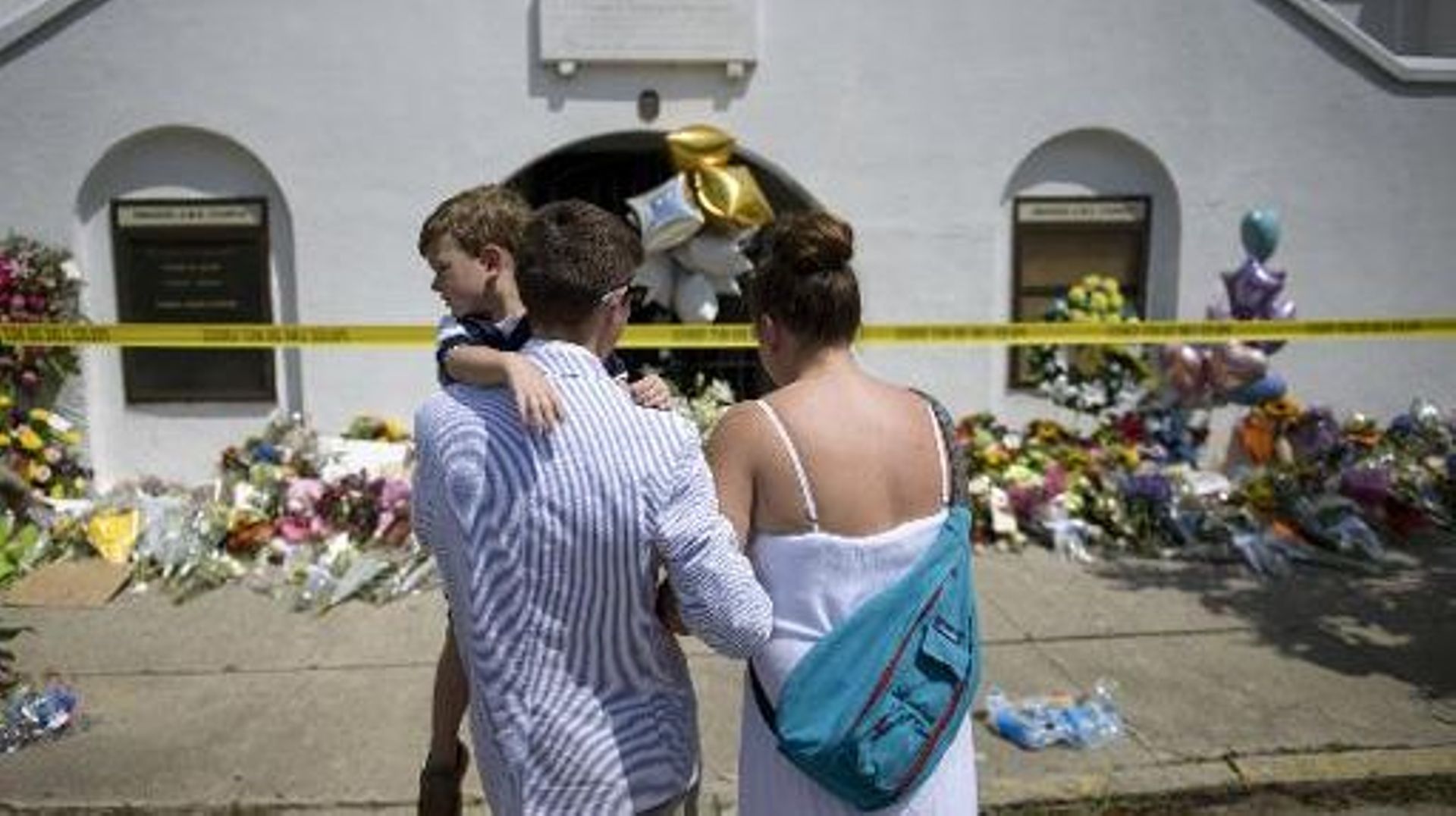 Une famille vient se recueillir devant l'église Emanuel, le 19 juin 2015 à Charleston