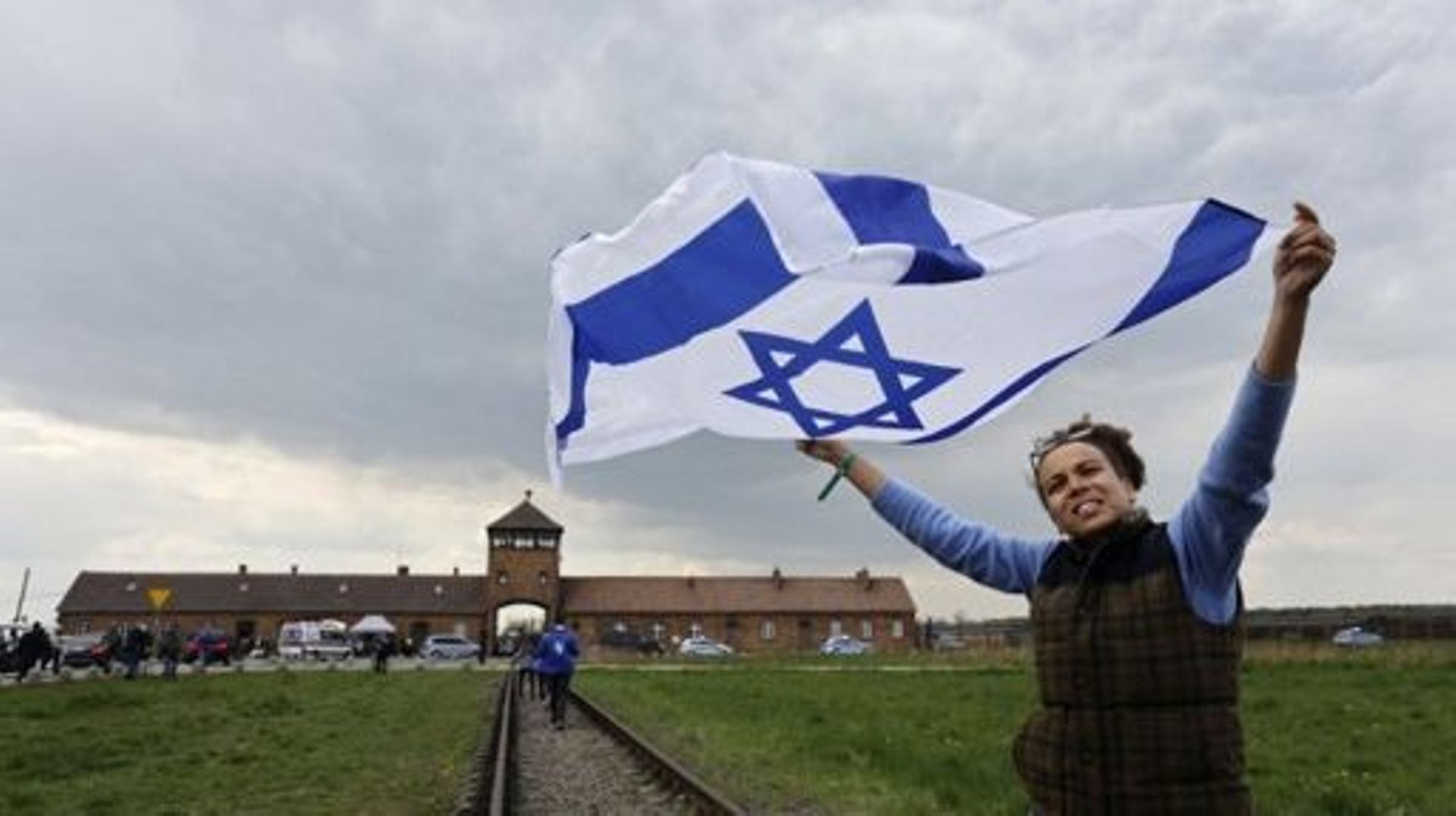 A particpant holds up the national flag of Israel on the sidelines of The March of the Living that takes places at the site of the former Auschwitz-Birkenau camp to honour the victims of the Holocaust, near the historical gate of Birkenau (Auschwitz II) n