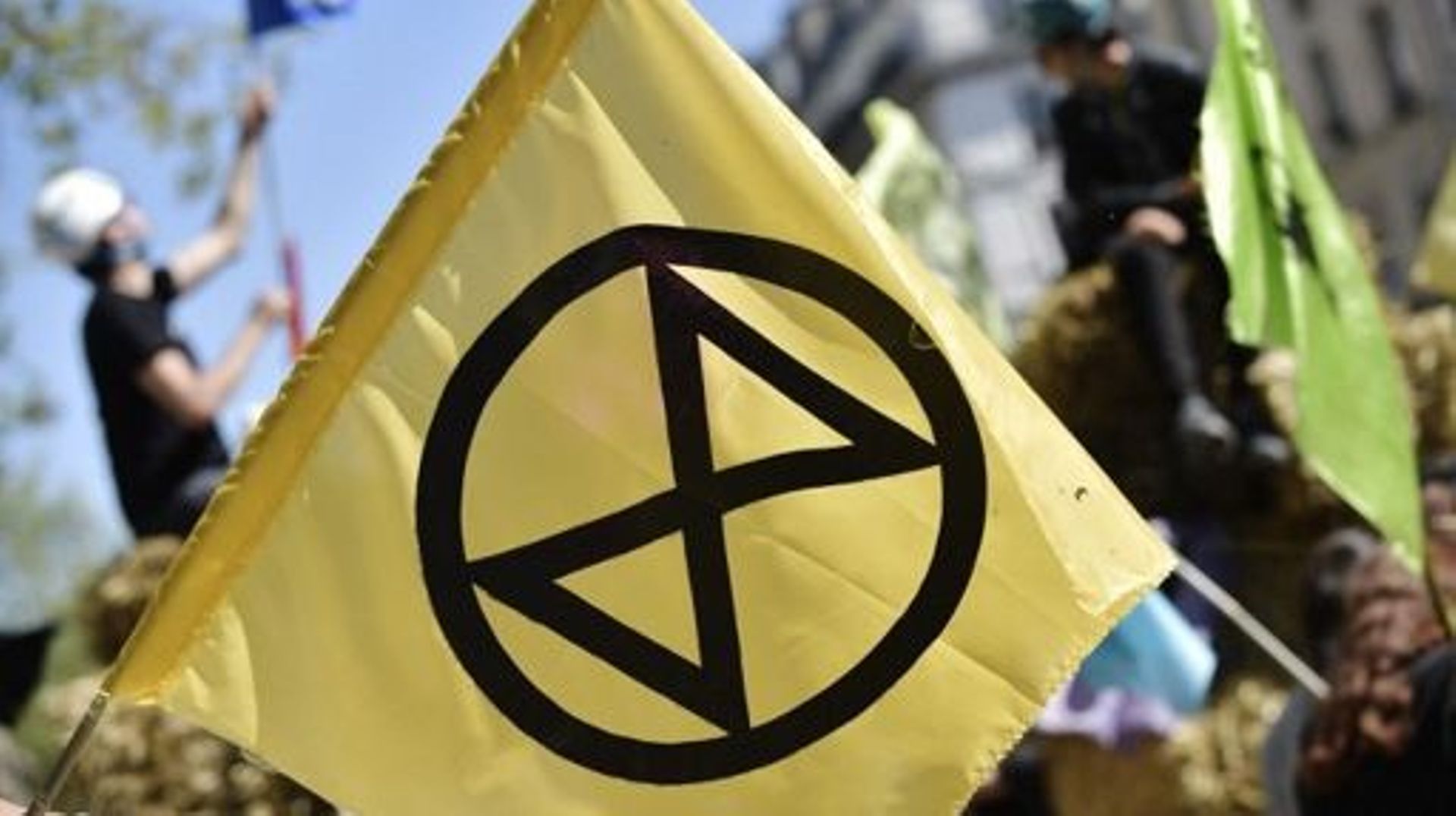 A flag with the logo of the climate change action group Extinction Rebellio is seen as activits of the climate change action group Extinction Rebellion block the Paris Grand Boulevard during a demonstration in Paris, on April 16 2022. A few hundred activi