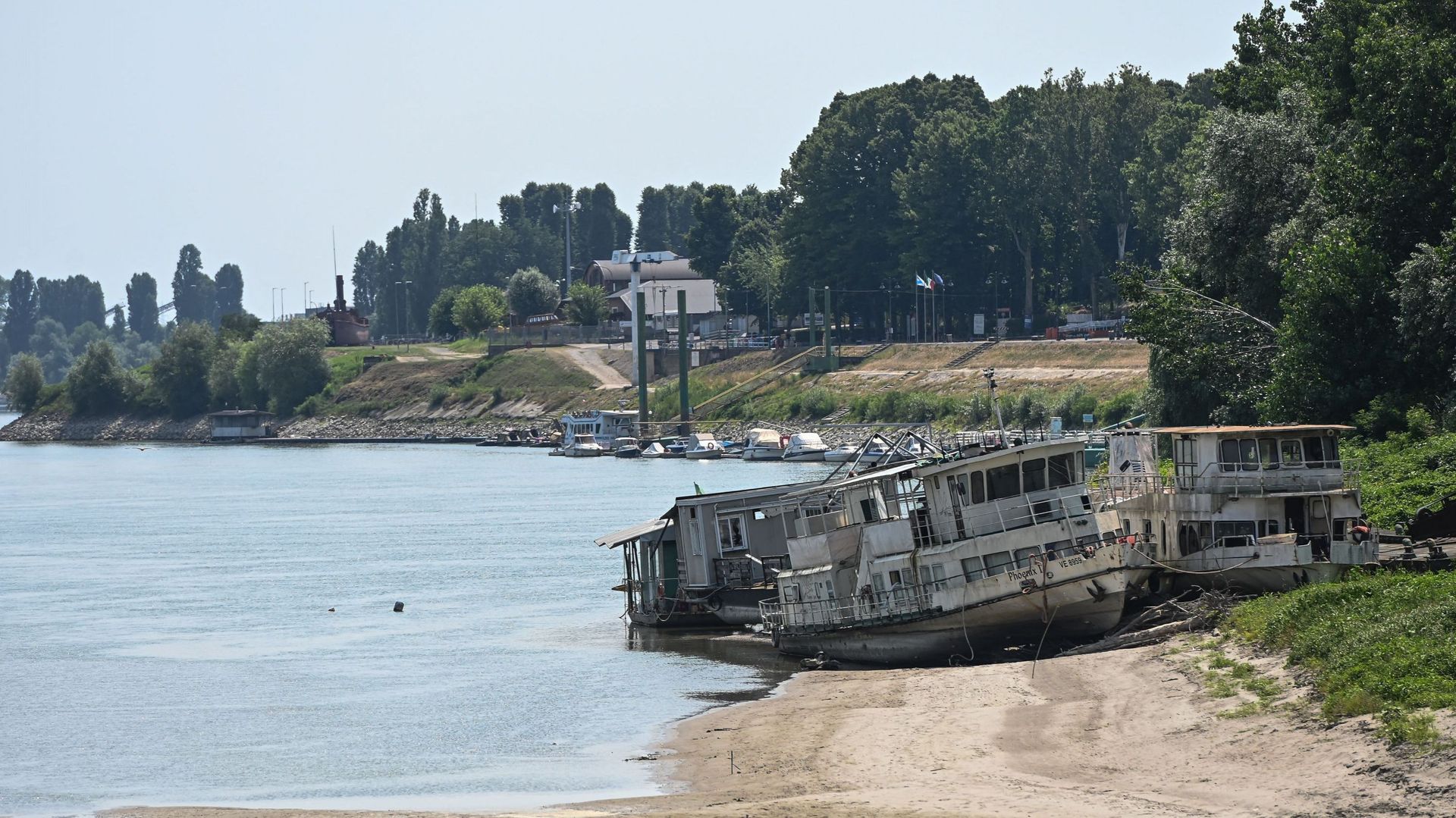 Des bateaux gisent sur une rive desséchée du fleuve Pô à Boretto, au nord-est de Parme, le 15 juin 2022. Selon l'observatoire fluvial, la sécheresse qui touche le plus long fleuve d'Italie, le Pô, est la pire de ces 70 dernières années. 