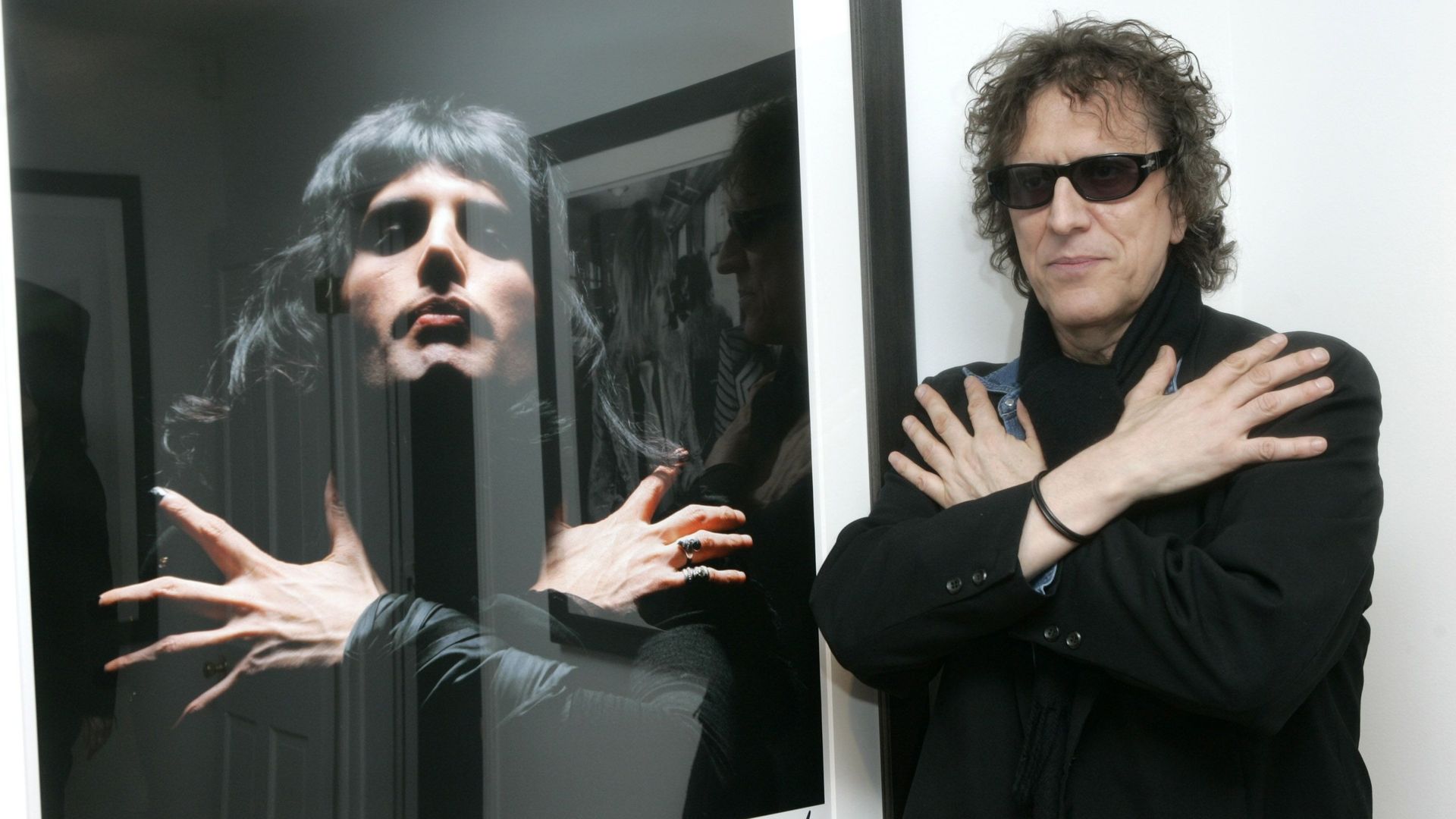 Mick Rock a côté d’un ses portraits de Freddie Mercury