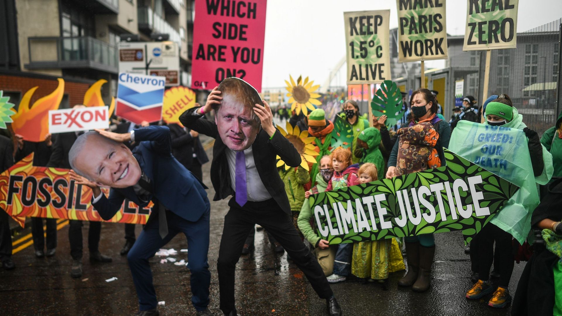 Des manifestants portant des masques de Joe Biden et Boris Johnson, à l’entrée de la COP26, ce 12 novembre