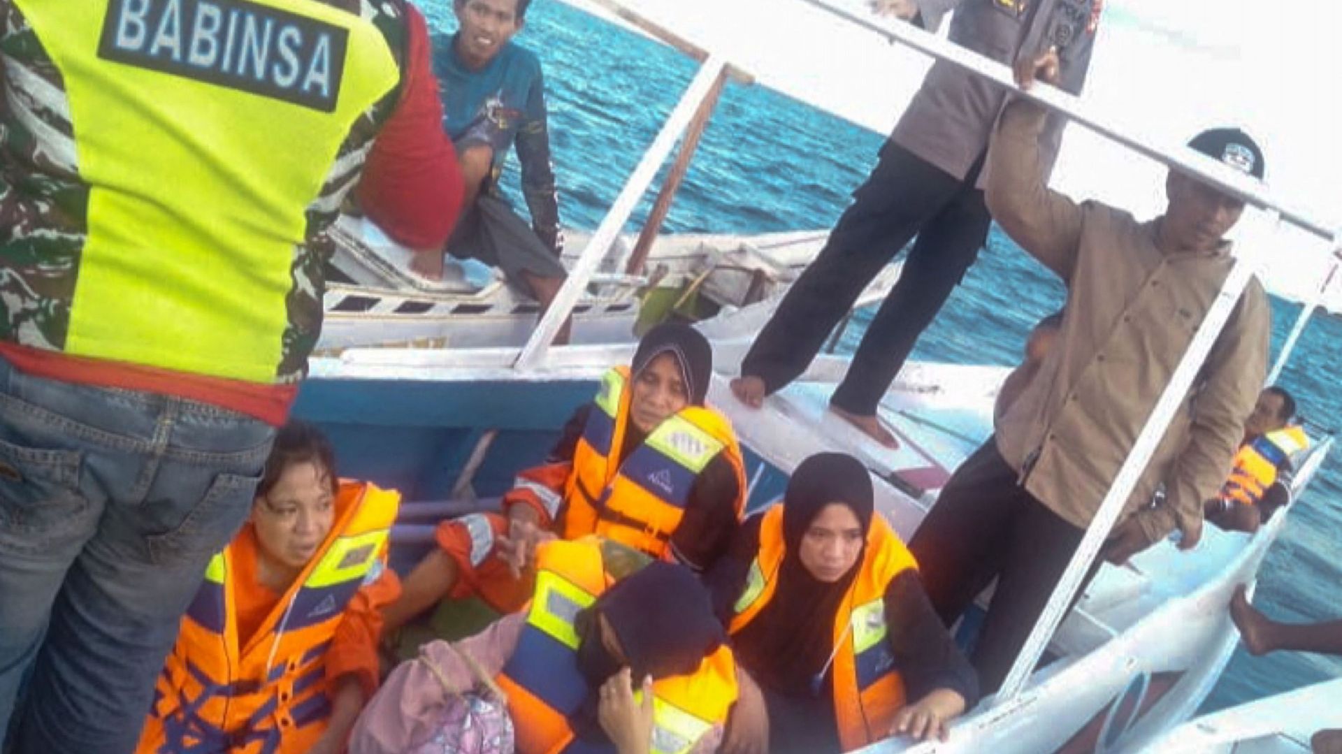Cette photo prise et publiée le 28 mai 2022 par l'Agence indonésienne de recherche et de sauvetage (BASARNAS) montre une équipe de sauvetage évacuant quelques survivants après le naufrage d'un ferry avec 43 passagers dans le détroit de Makassar.