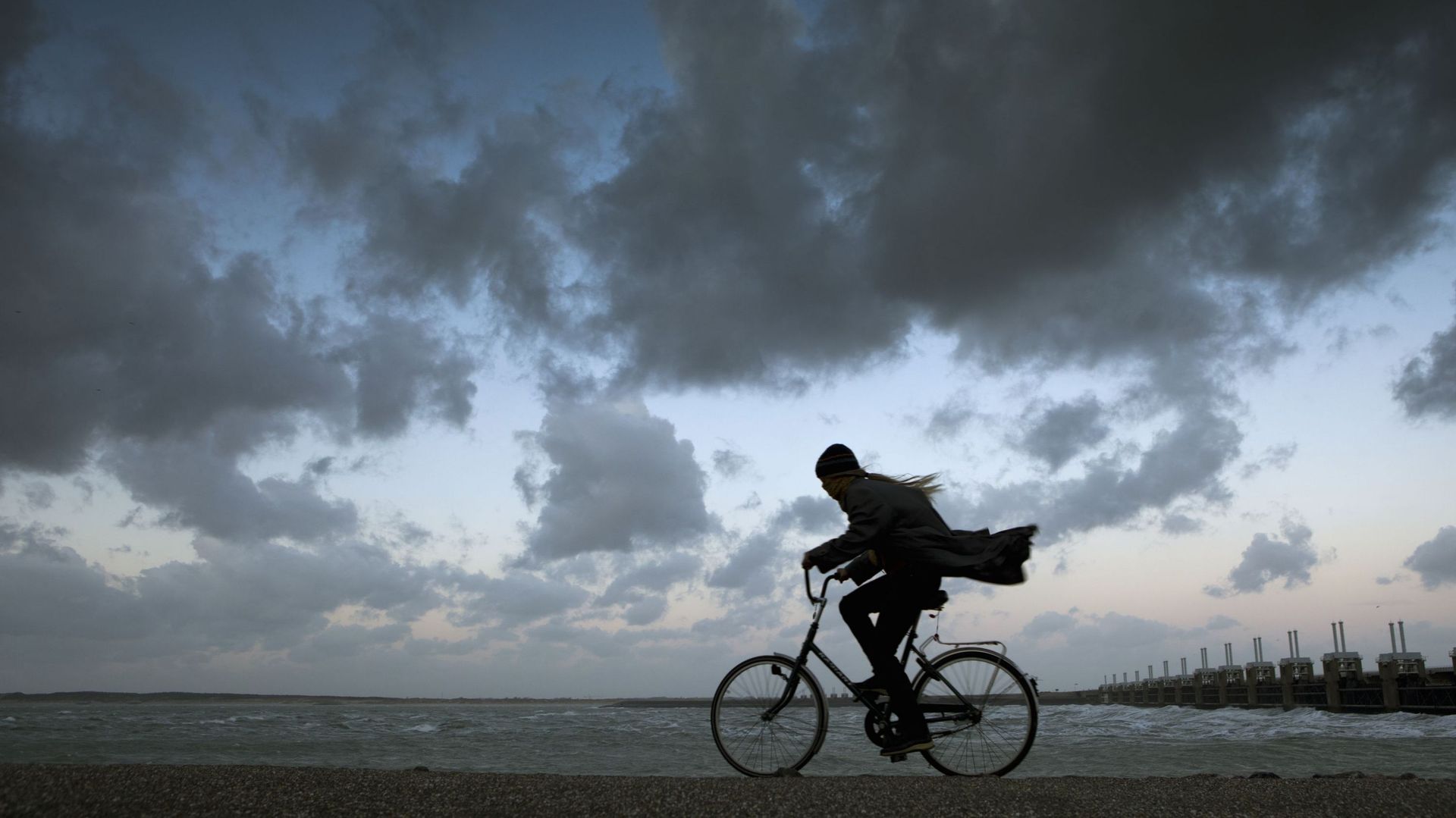 Netherlands, Kamperland. Woman Cycles During Storm
