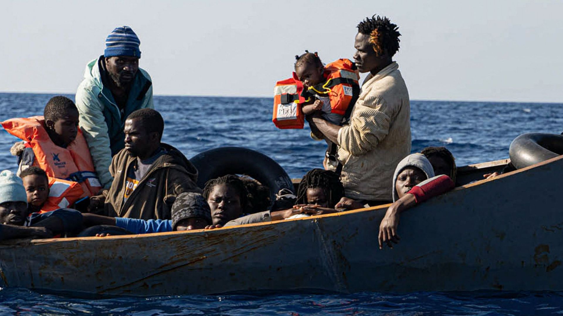 Cette photo prise le 3 novembre 2022 et distribuée le 5 novembre 2022 par l’ONG Mission Lifeline, qui bat pavillon allemand, montre des migrants, dont des enfants, se préparant à monter à bord du navire de sauvetage "Rise Above" après avoir été secourus.