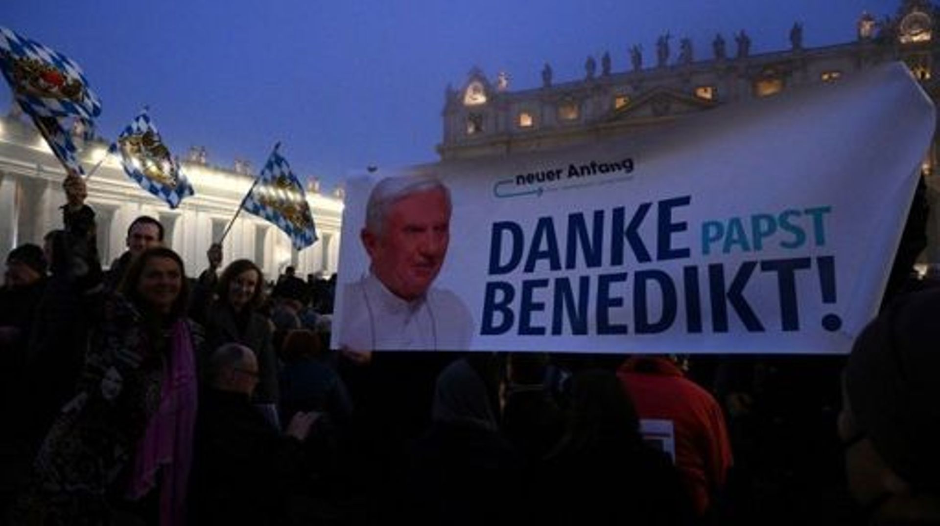 People hold a banner reading, in German "Thank you Pope Benedict" prior to the funeral mass of Pope Emeritus Benedict XVI at St. Peter’s square in the Vatican, on January 5, 2023. Pope Francis will preside on January 5 over the funeral of his predecessor