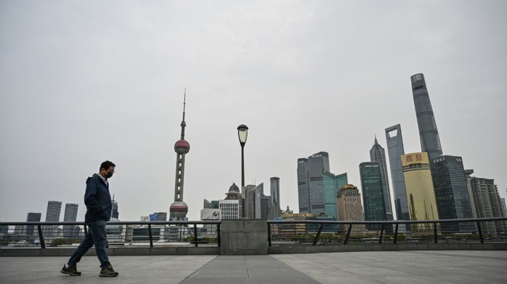 Un homme marche sur le Bund, artère historique  de Shanghai le 28 mars 2022