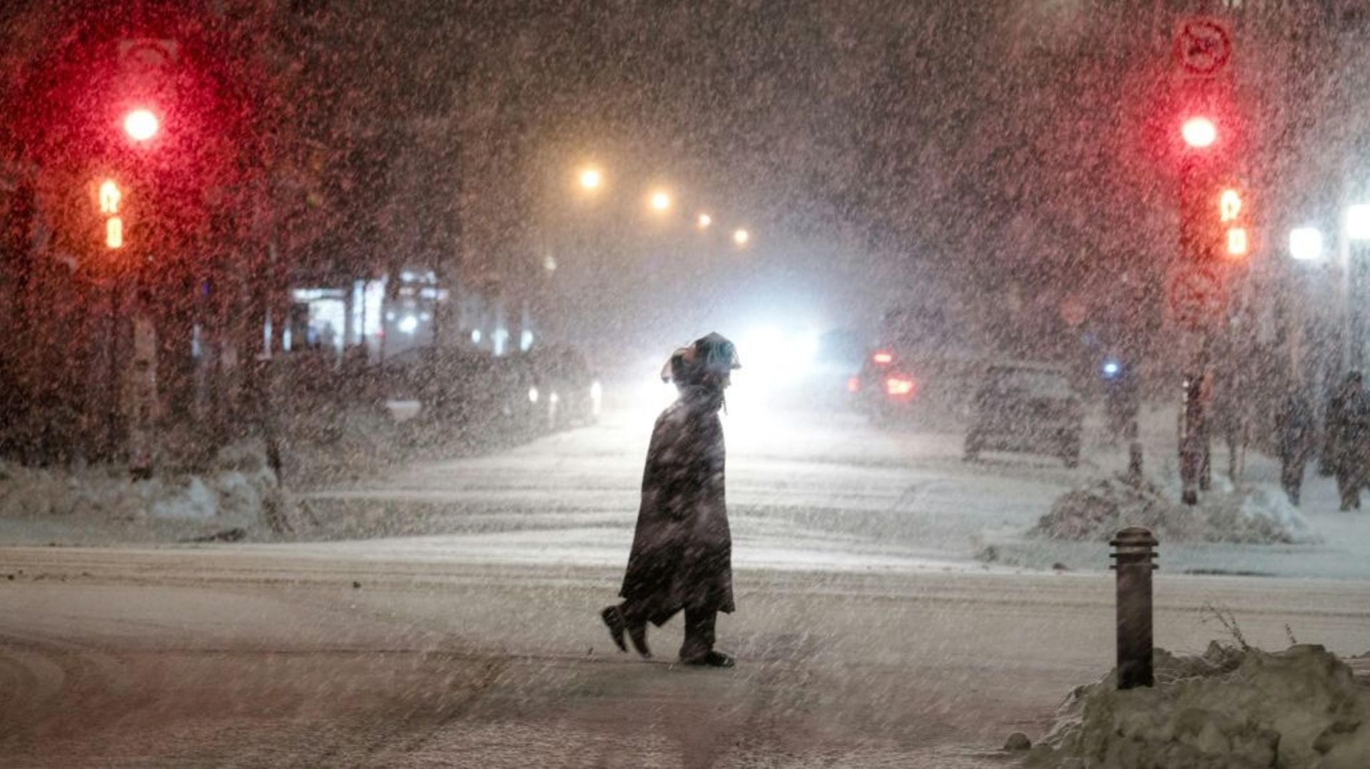 Un piéton traverse une rue enneigée pendant une tempête, le 22 décembre 2022 à Montréal, au Canada.