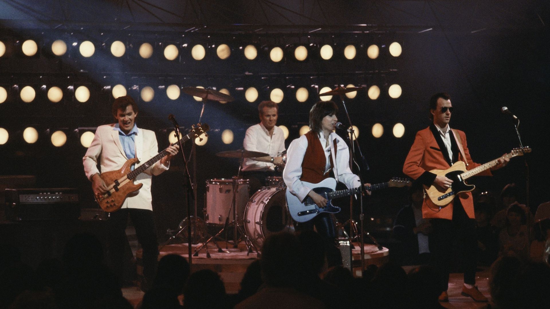 Les Pretenders sur scène en 1984 à Los Angeles (de gauche à droite : Malcom Foster, Martin Chambers, Chrissie Hynde et Robbie McIntosh.