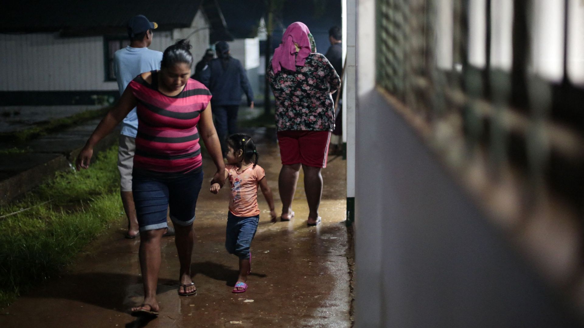 Une femme et sa fille marchent dans un abri temporaire avant l'arrivée de la tempête tropicale Bonnie à Bluefields, au Nicaragua, le 1er juillet 2022. 