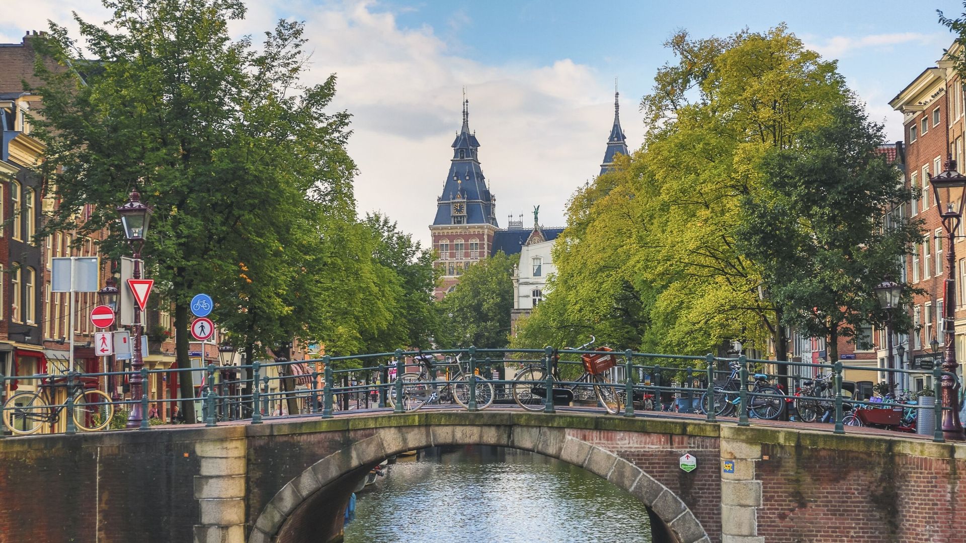 Pont donnant sur le canal Spiegelgracht avec le Rijksmuseum en arrière-plan, emblème d’Amsterdam, Pays-Bas.