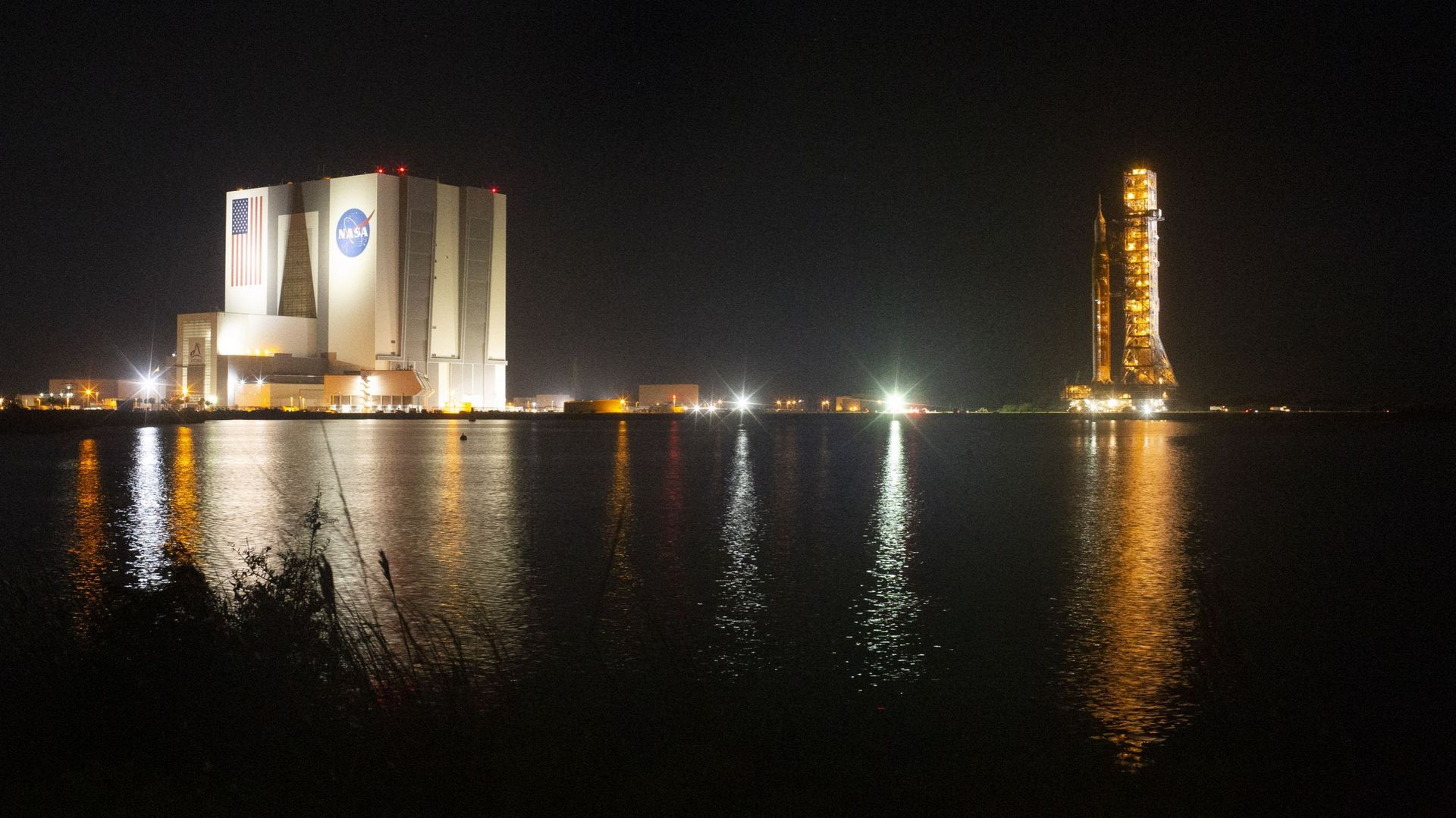 Sur cette photo fournie par la NASA, la fusée Space Launch System (SLS) de la NASA avec le vaisseau spatial Orion à bord est vue au sommet du lanceur mobile alors qu'elle sort du Vehicle Assembly Building pour rejoindre la rampe de lancement 39B au Kenned