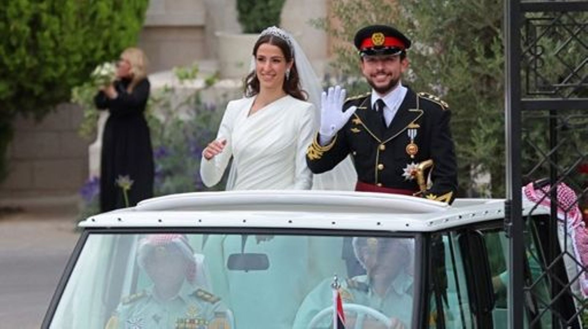 Jordan’s Crown Prince Hussein (R) and his wife Saudi Rajwa al-Seif wave as they leave the Zahran Palace in Amman on June 1, 2023 following their royal wedding ceremony. The ceremony was held in the mid-century Zahran Palace-- the site of other key royal w