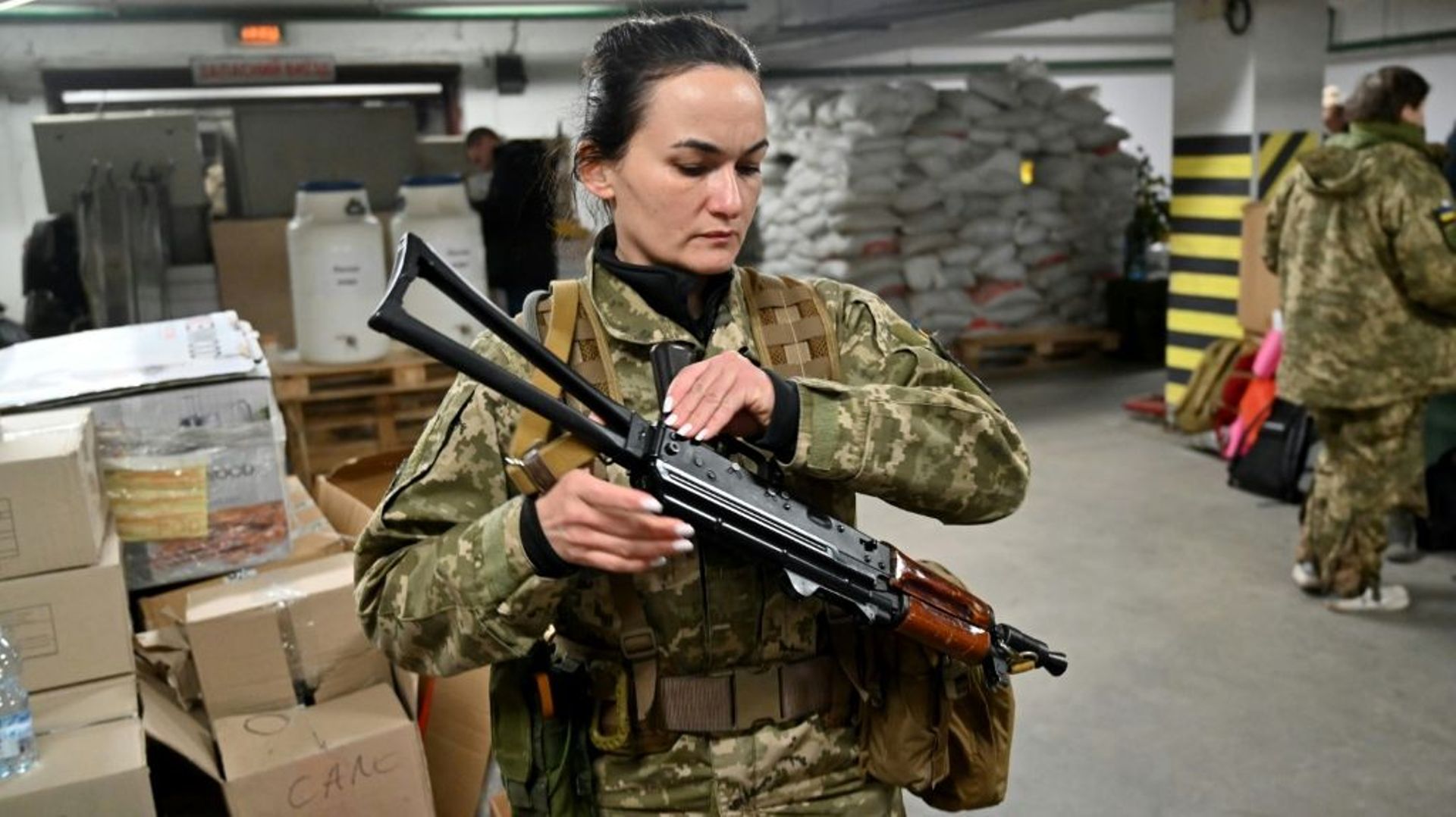 Iryna Sergueïeva, première combattante volontaire ukrainienne à signer un contrat militaire de plein droit, armée d'une kalachnikov, dans un parking souterrain transformé en centre d'entraînement et de logistique, le 11 mars 2022 à Kiev
