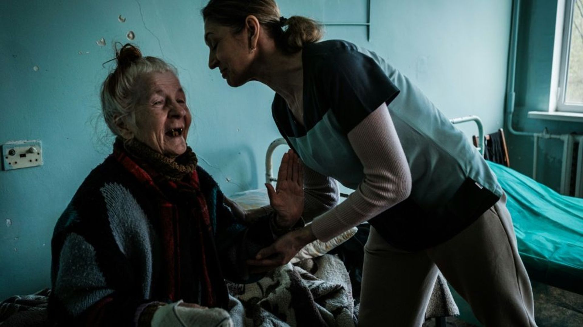 Une infirmière parle à une Ukrainienne déplacée âgée de 81 ans dans un hôpital de Severodonetsk dans l’Est de l’Ukraine, le 22 avril 2022