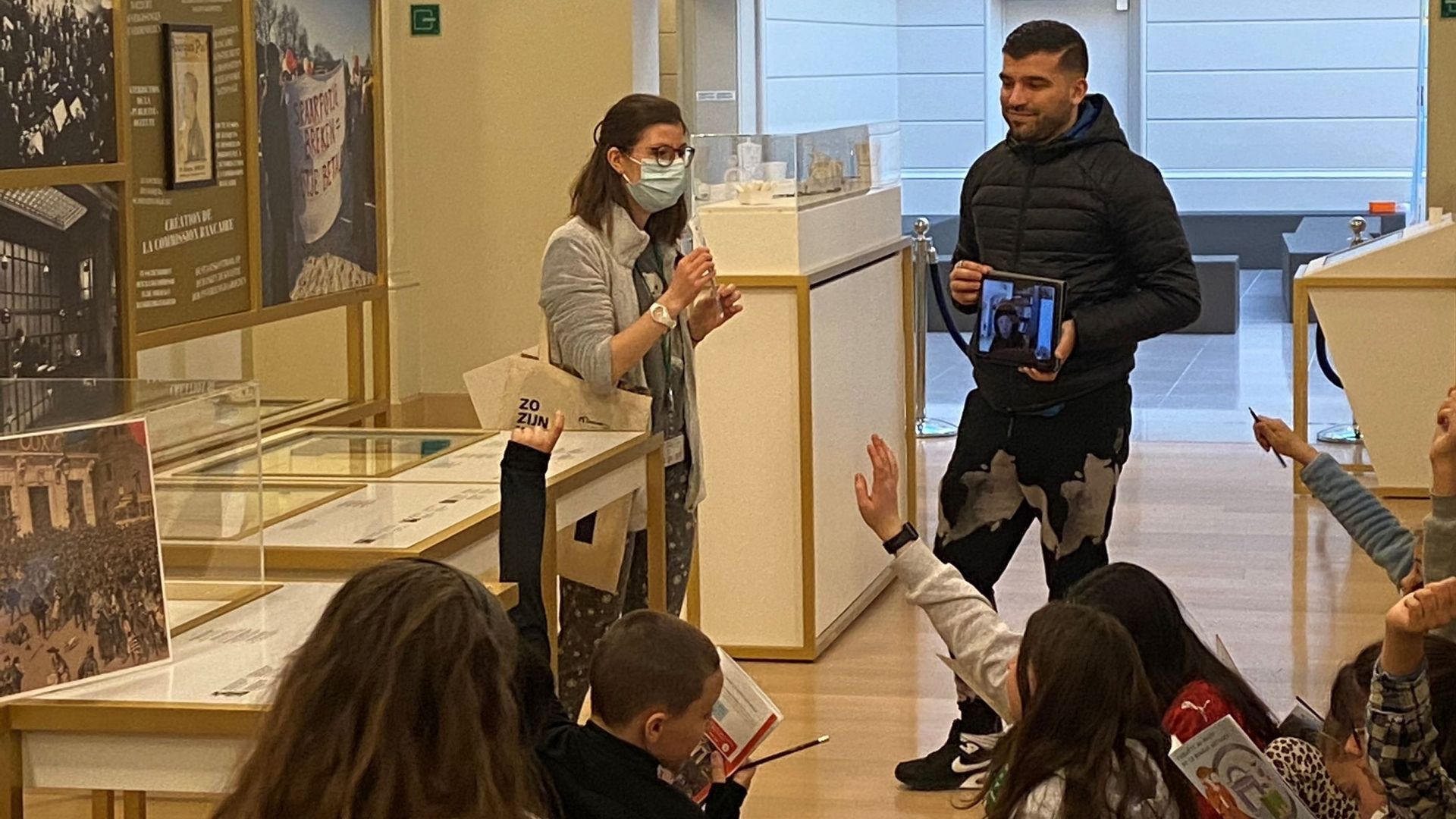 Une classe schaerbeekoise en visite au Musée de la Banque nationale. La tablette permet à un enfant qui doit rester à la maison de participer à l’activité.