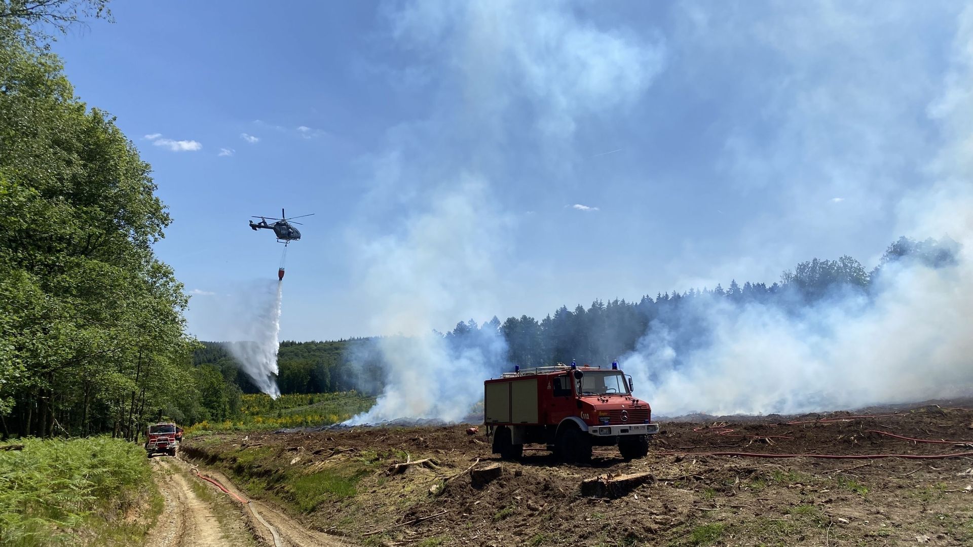 Exercice de grande ampleur de lutte contre les feux de forêts à Vresse, un hélicoptère de la police fédérale largue de l’eau sur l’incendie.