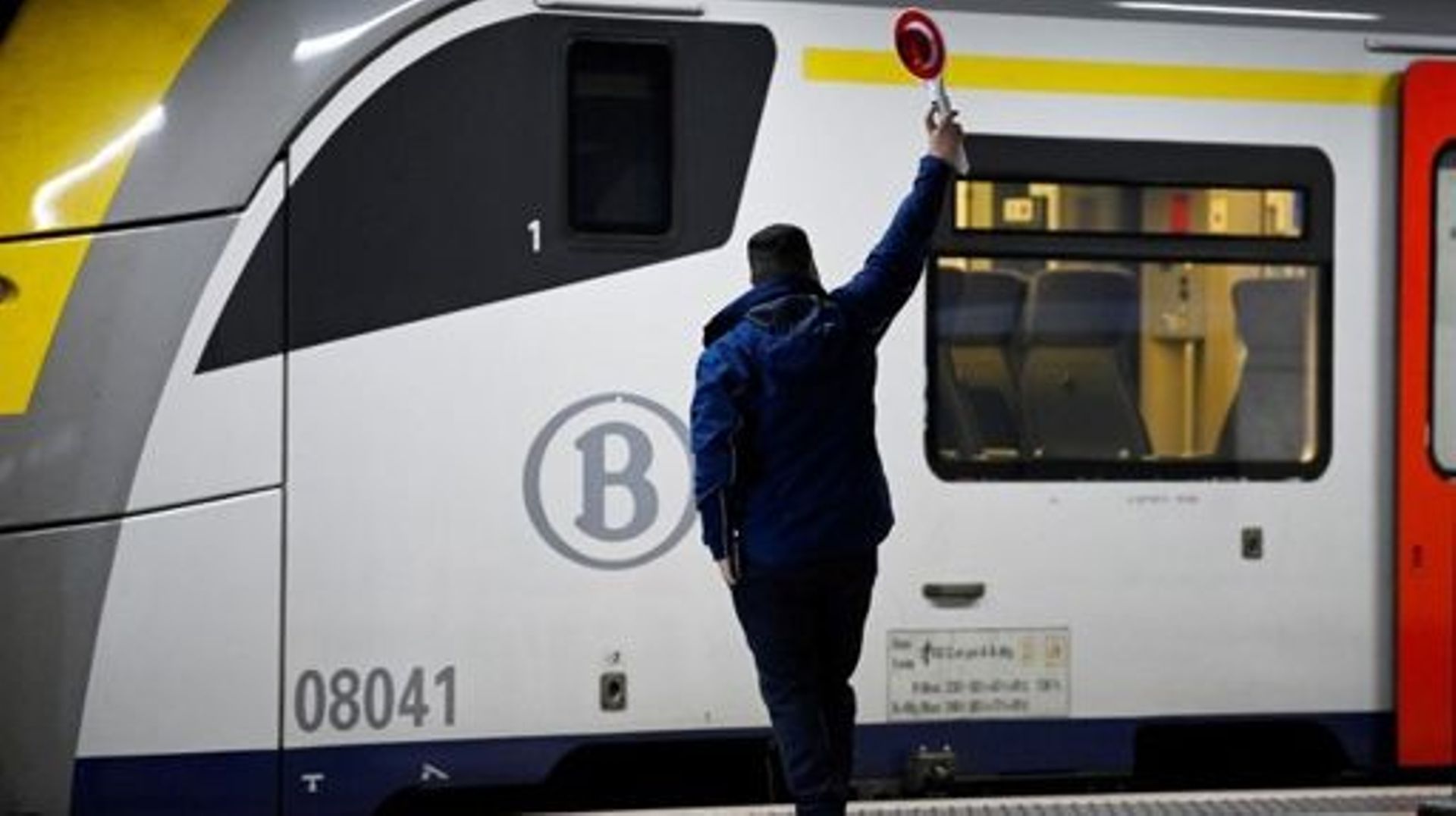 Station master sends a signal near the National Railway Company of Belgium (SNCB) train at Brussels-Schuman railway station on November 8, 2022.  John THYS / AFP