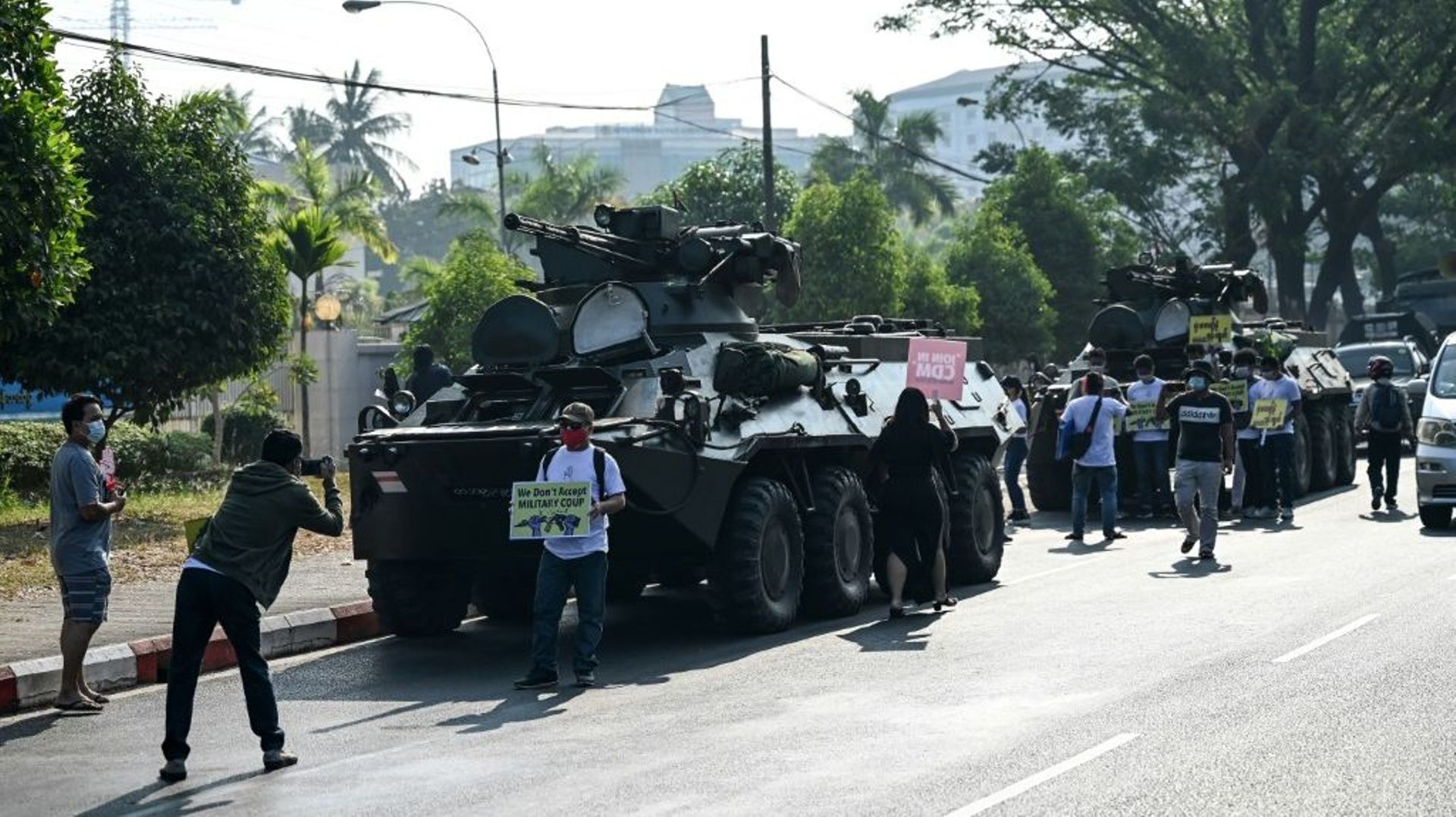 Des manifestants se rassemblent près des blindés déployés dans le centre de Rangoun, le 15 février 2021