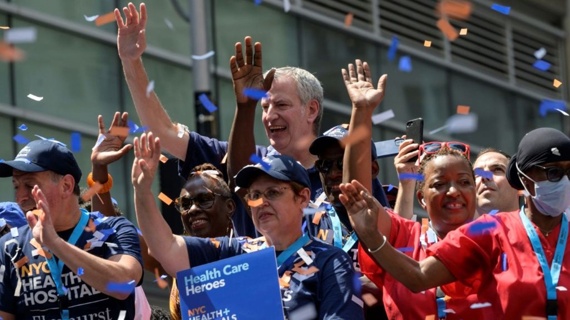 Le maire de New York Bill De Blasio (c) avec des travailleurs essentiels, lors d’une parade en leur honneur, le 7 juillet 2021 à New York