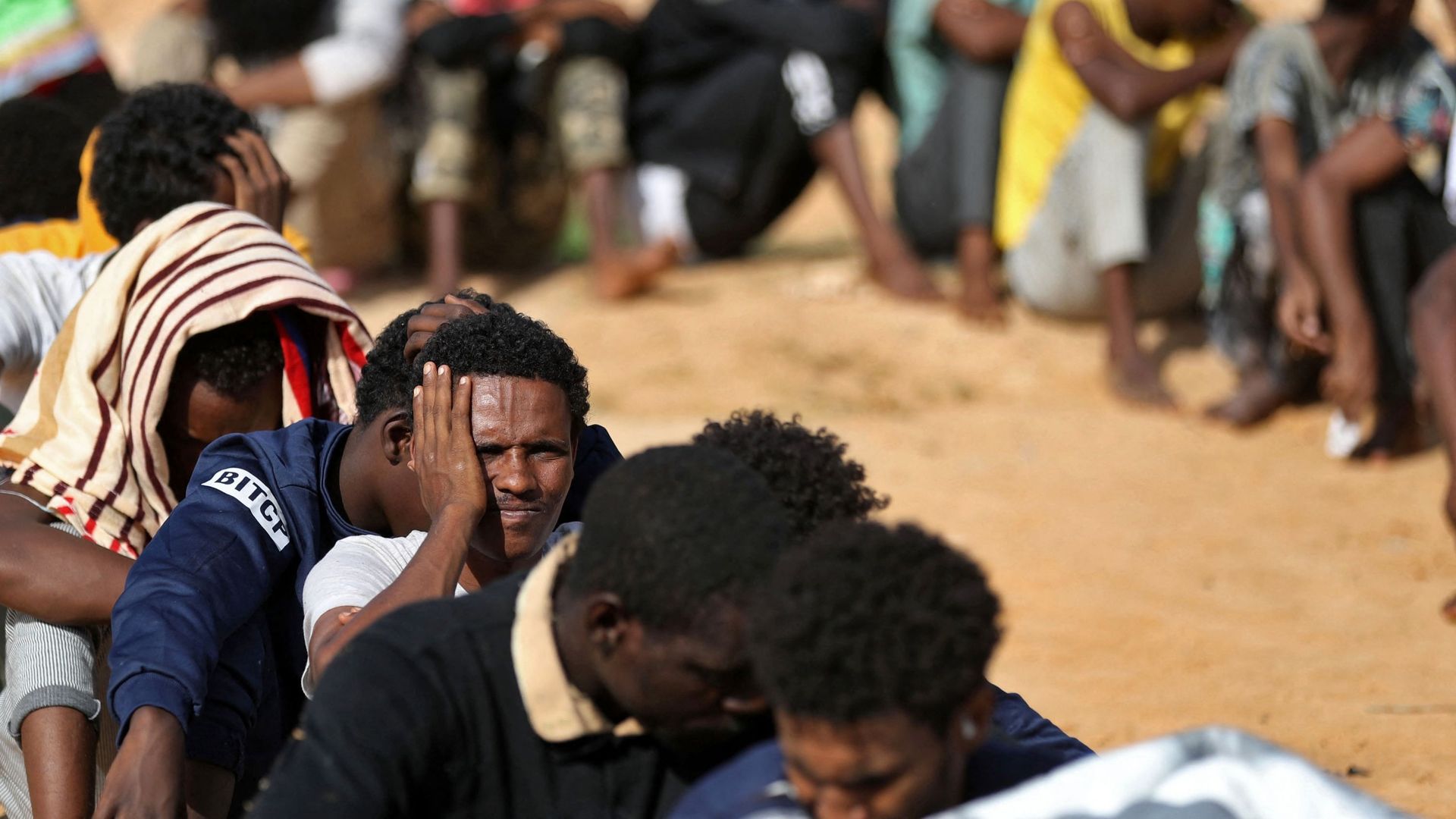 Des migrants africains se rassemblent dans un abri de fortune dans la banlieue de la capitale libyenne Tripoli, Ain Zara, le 11 octobre 2021.