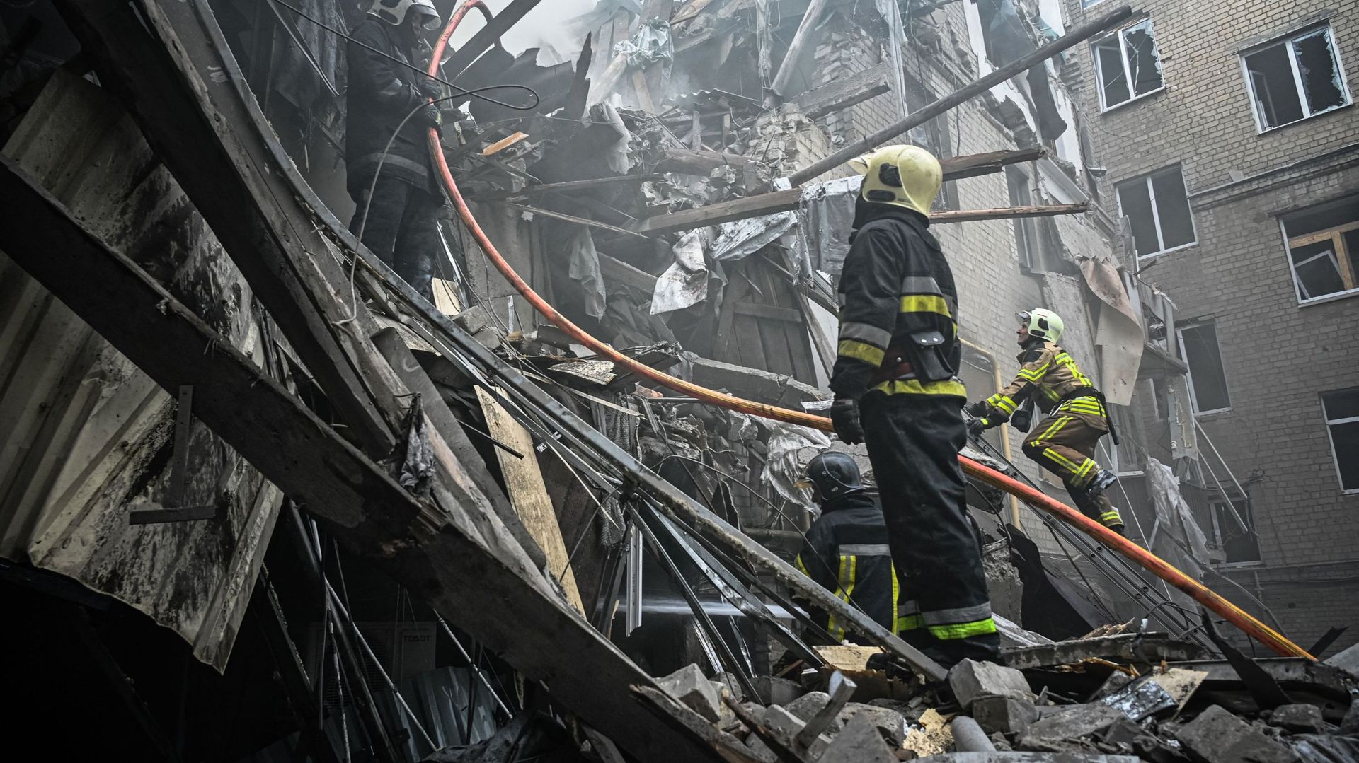 Des pompiers éteignent un incendie après qu'un appartement ait été touché par un tir de missile à Kharkiv, le 6 septembre 2022.