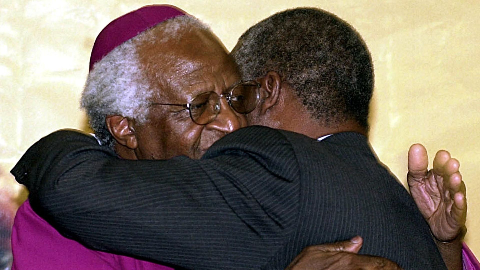 Desmond Tutu (à gauche) embrasse le président sud-africain Thabo Mbeki, le 21 mars 2003, après lui avoir remis le rapport vérité et réconciliation à Pretoria.