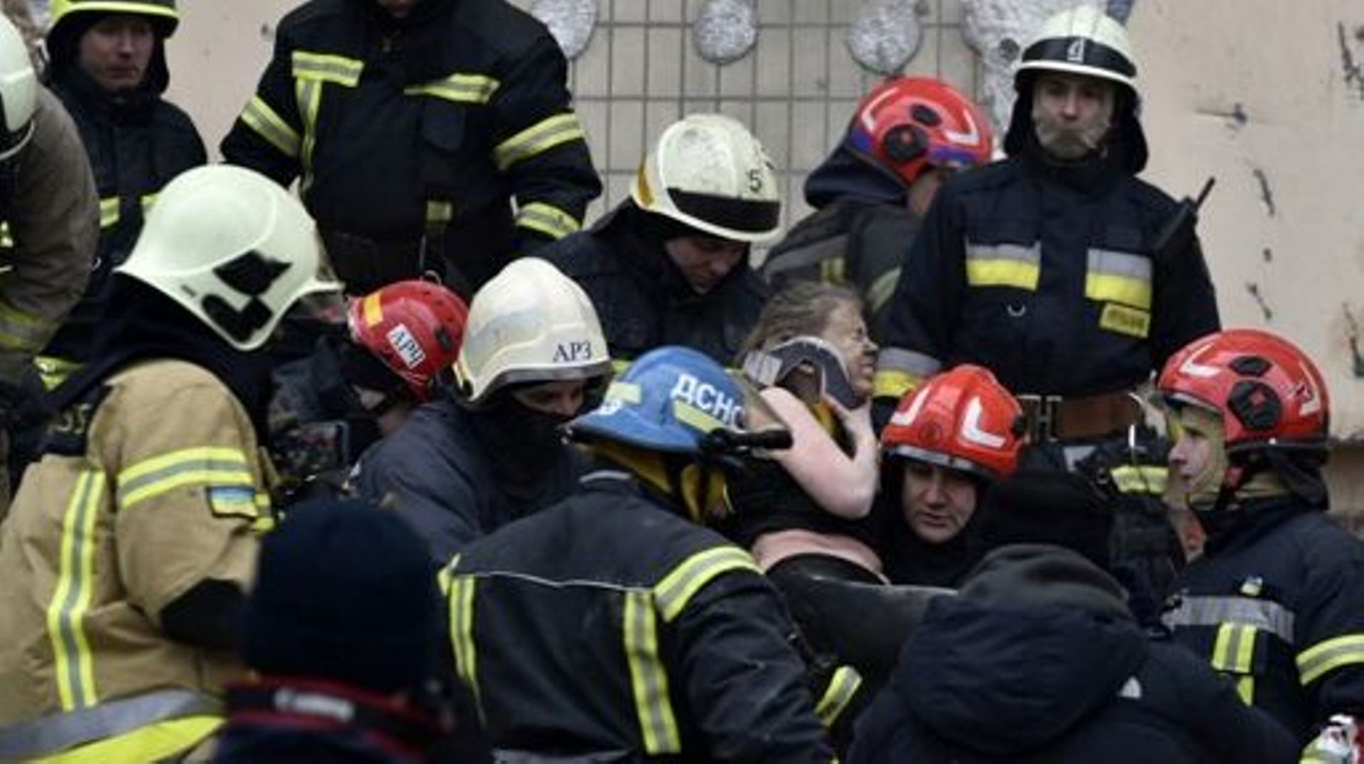 Rescuers carry a woman evacuated from the rubble of a residential building destroyed after a missile strike, in Dnipro on January 15, 2023, amid the Russian invasion of Ukraine.                The death toll rose to at least 20 on January 15 after a strik