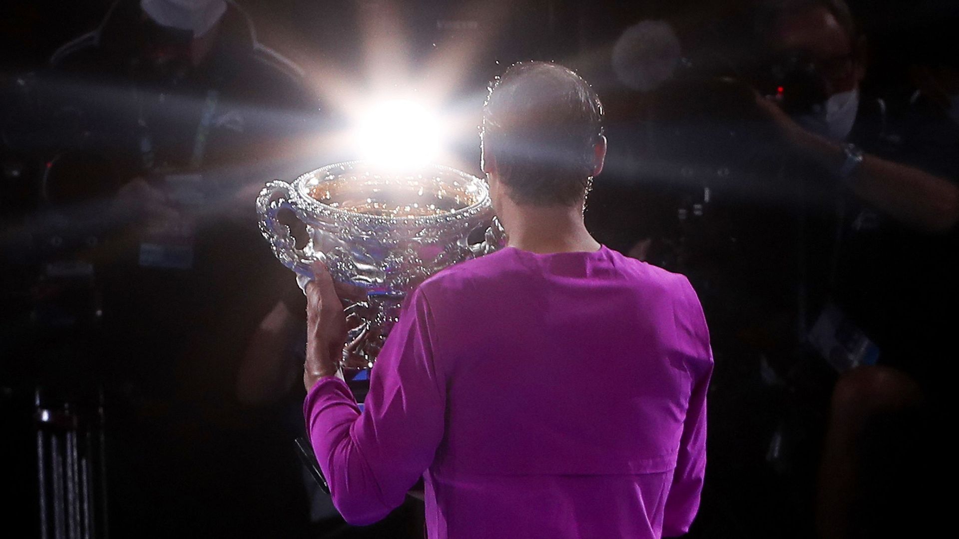 Nadal pose avec son trophée de l’Australian Open, son 21e tournoi du Grand-Chelem remporté, sous les flashes des appareils photos