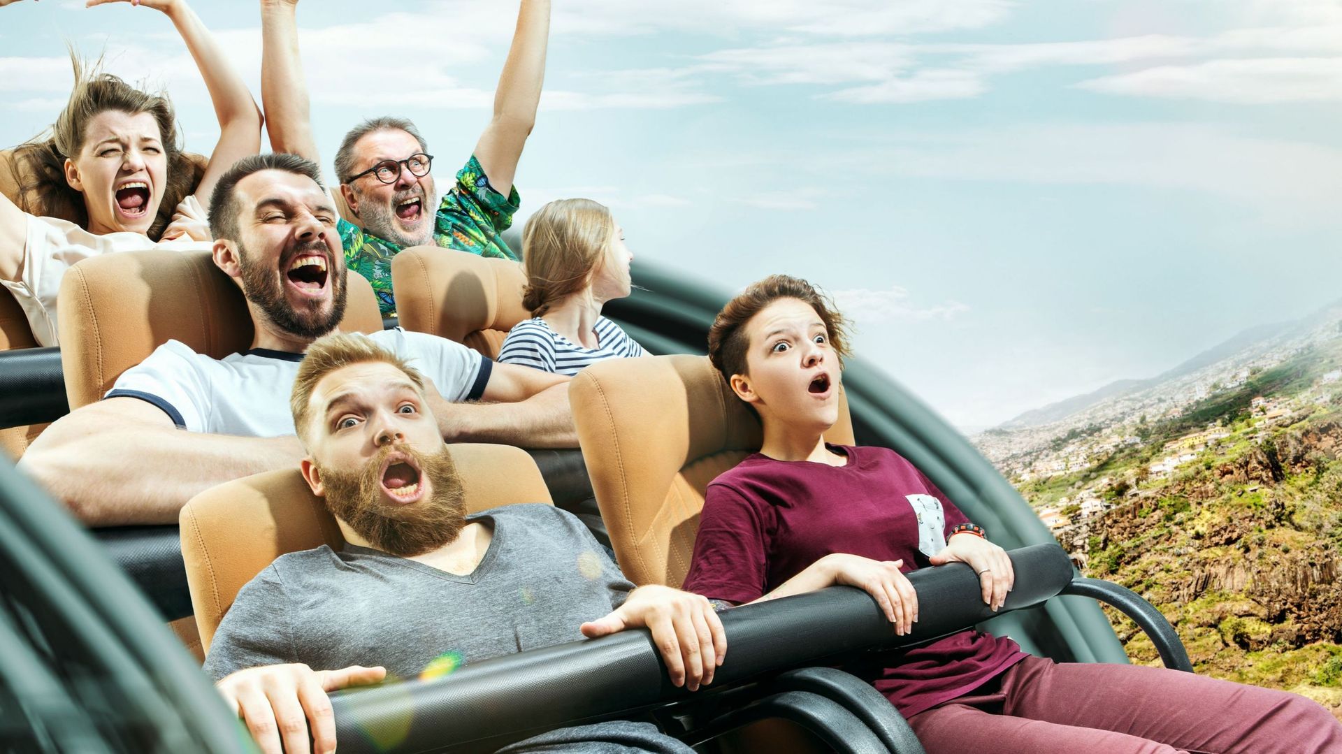 The happy emotions of men and women having good time on a roller coaster in the park