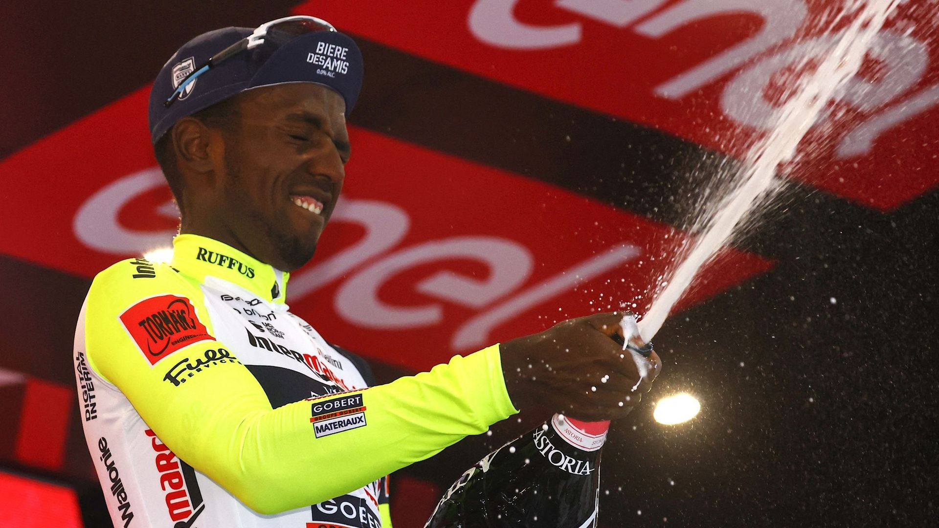 Biniam Girmay, coureur cycliste érythréen, ouvre une bouteille de Prosecco pour célébrer sa victoire d’étape sur le Giro 2022.