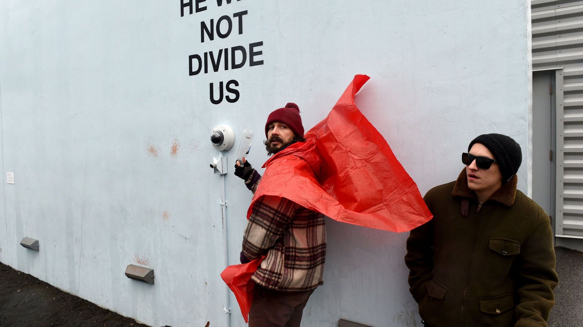 Le "happening" de Shia LaBeouf consiste en une caméra qui tourne 24h/24, fixée sur un mur. Les passants qui le souhaitent sont invités à se mettre devant l'objectif pour déclamer la phrase proposée par l'acteur: "He will not divide us"