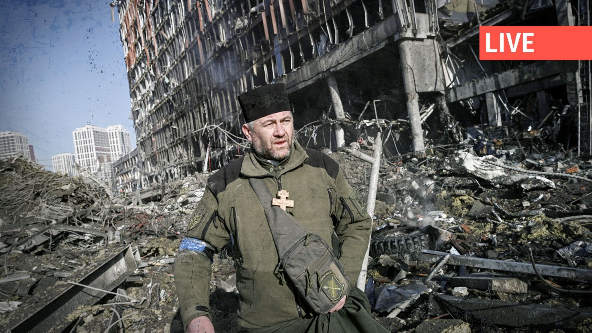 L'aumônier de l'armée ukrainienne Mikola Madenski marche parmi les débris à l'extérieur du centre commercial Retroville détruit dans un quartier résidentiel, après une attaque russe sur la capitale ukrainienne, Kiev, le 21 mars 2022.